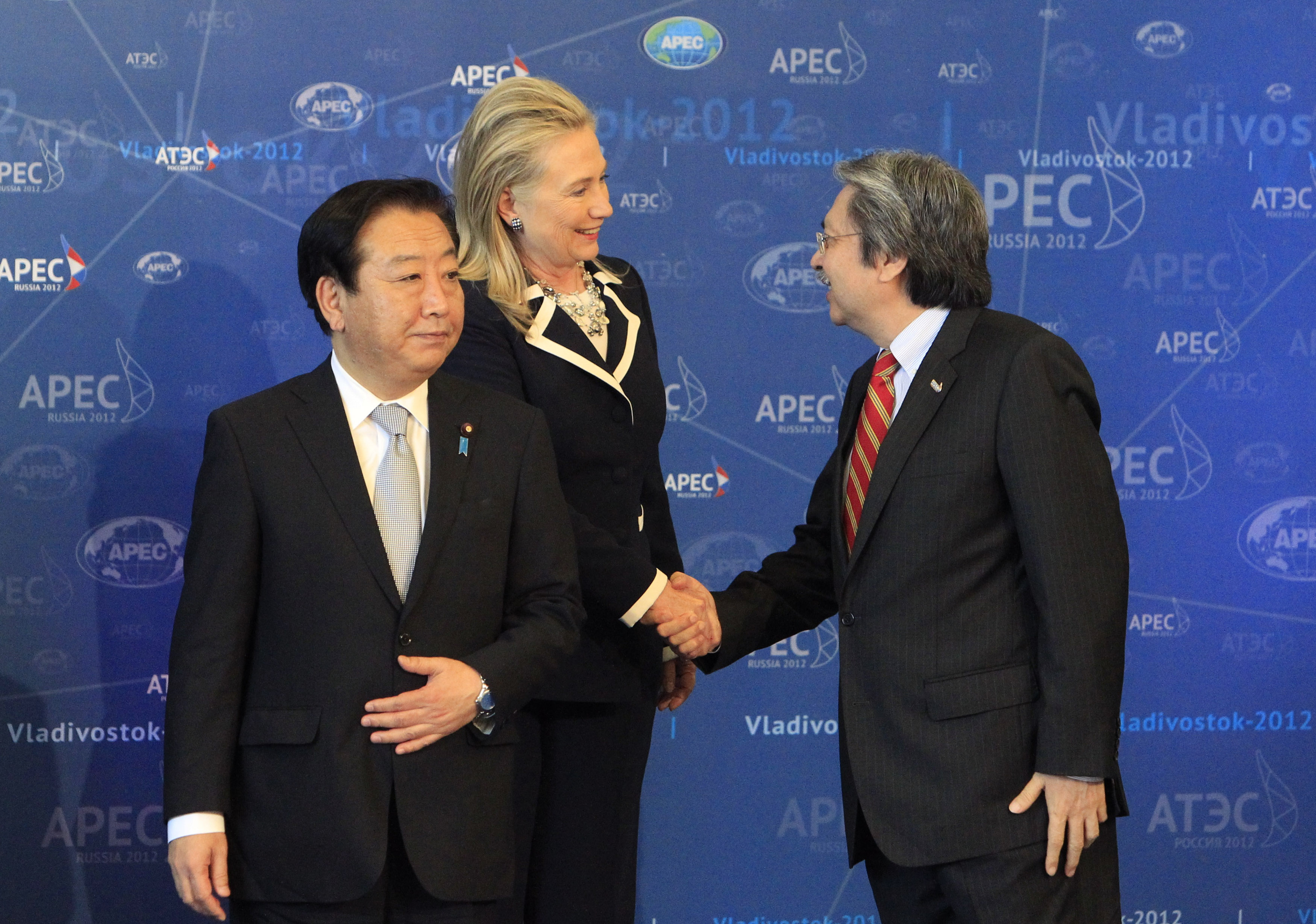 U.S. Secretary of State Hillary Clinton shakes hands with Hong Kong's Financial Secretary John Tsang during a group photo in Vladivostok