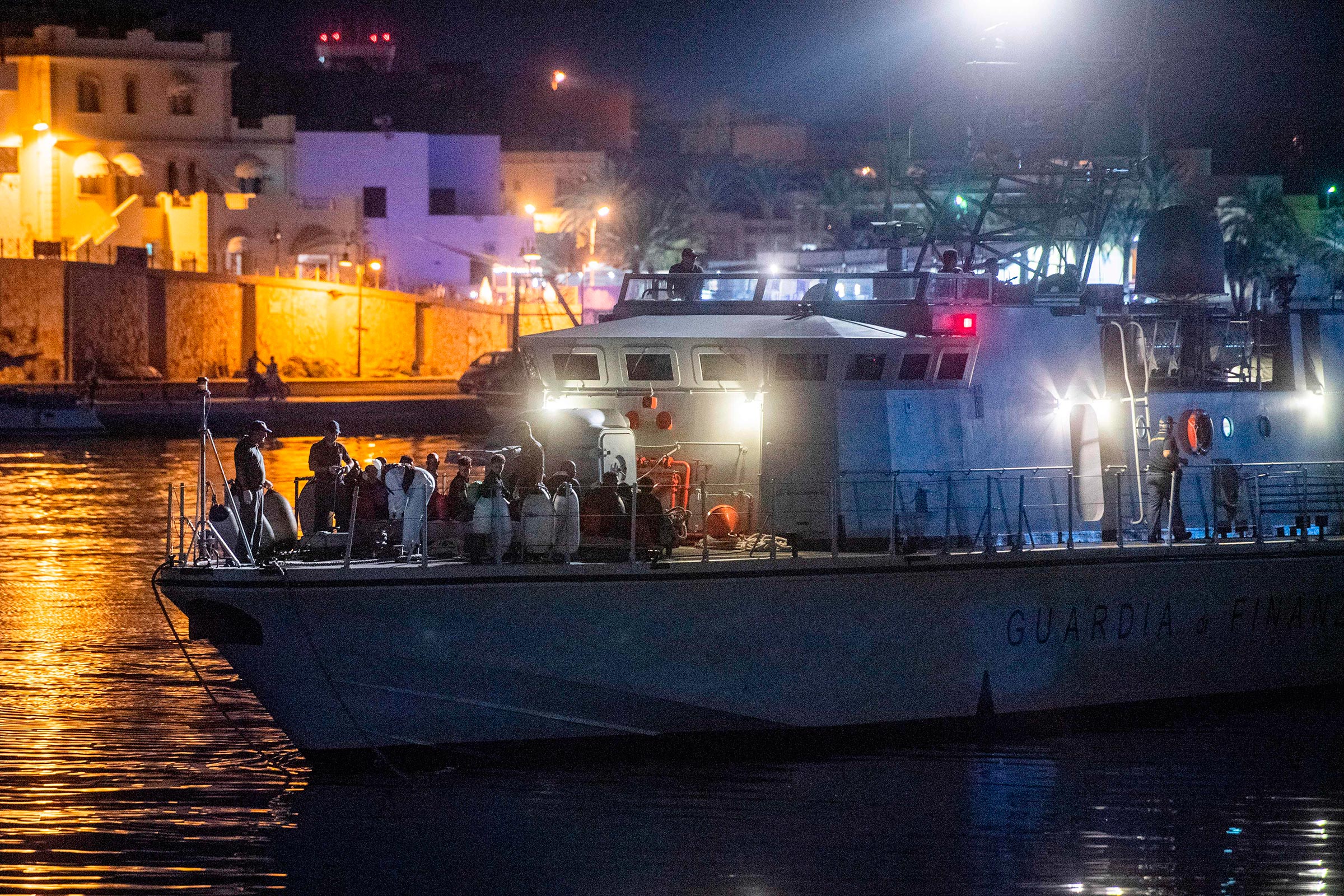 Migrants sit on an Italian coast guard ship after disembarking from the Ocean Viking ship rescue ship off Italy's southern island of Lampedusa in the Mediterranean Sea on Sept. 14, 2019.