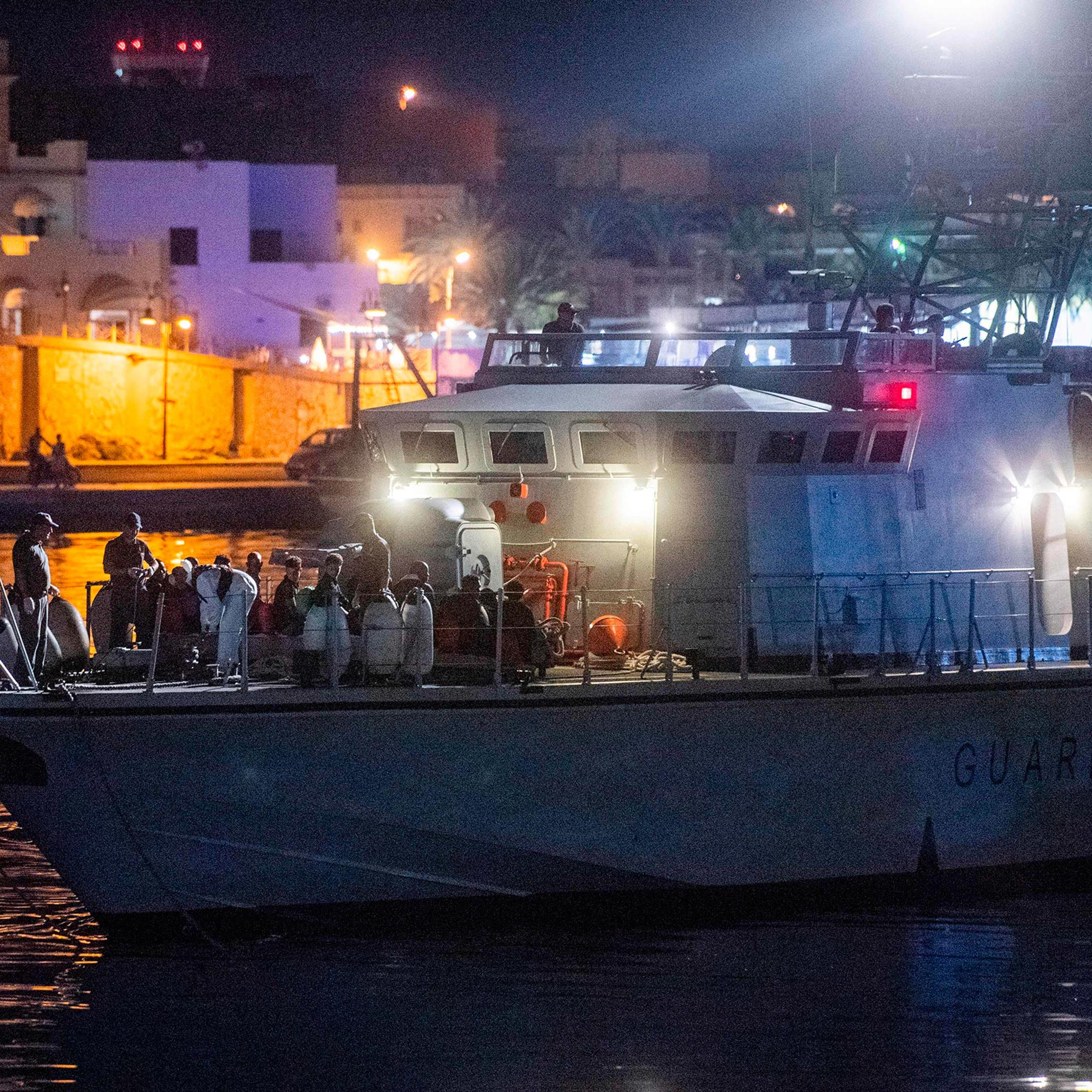 Migrants sit on an Italian coast guard ship after disembarking from the Ocean Viking ship rescue ship off Italy's southern island of Lampedusa in the Mediterranean Sea on Sept. 14, 2019.