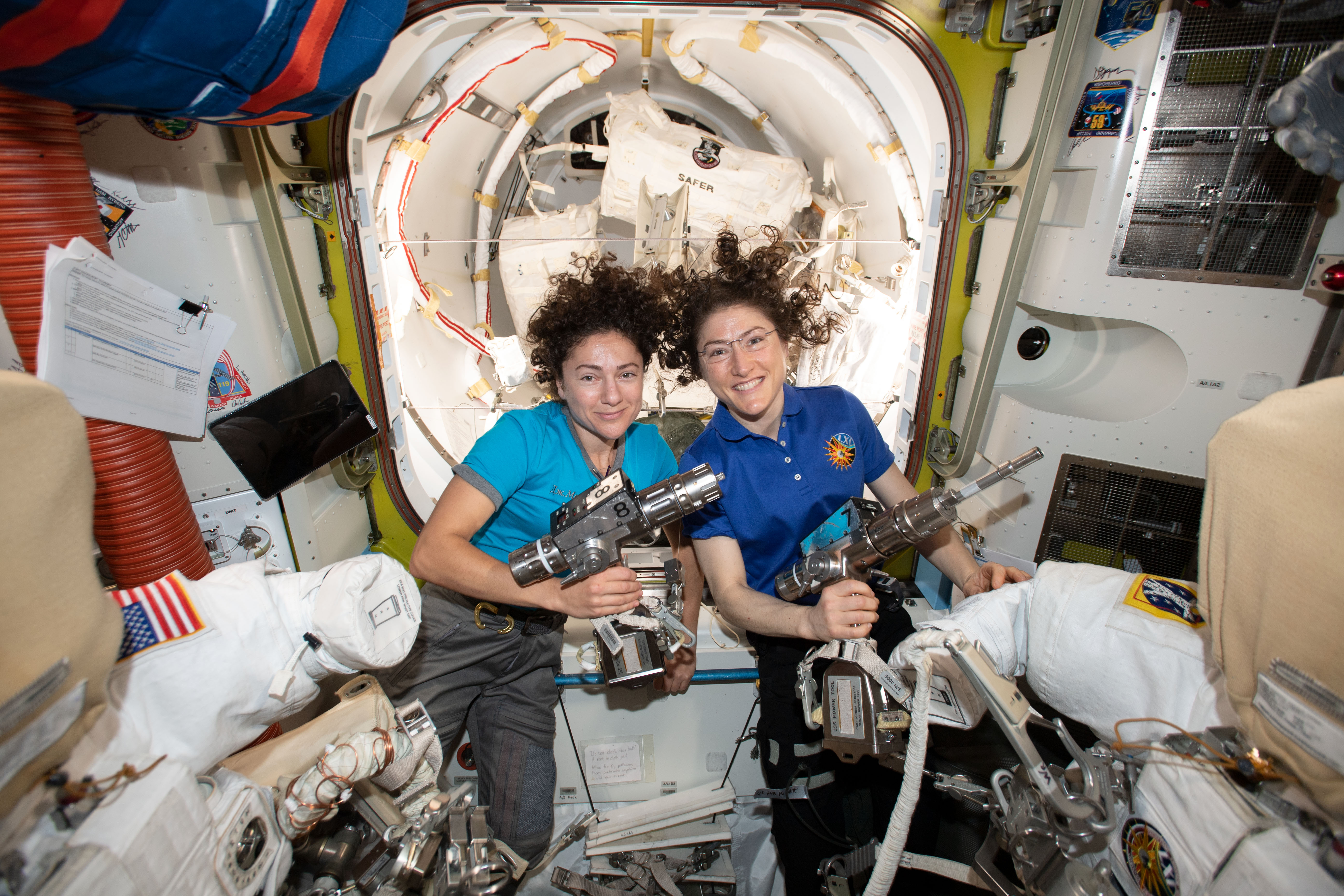 NASA astronauts Jessica Meir (left) and Christina Koch inside the Quest airlock preparing the U.S. spacesuits and tools they will use on their first spacewalk together.