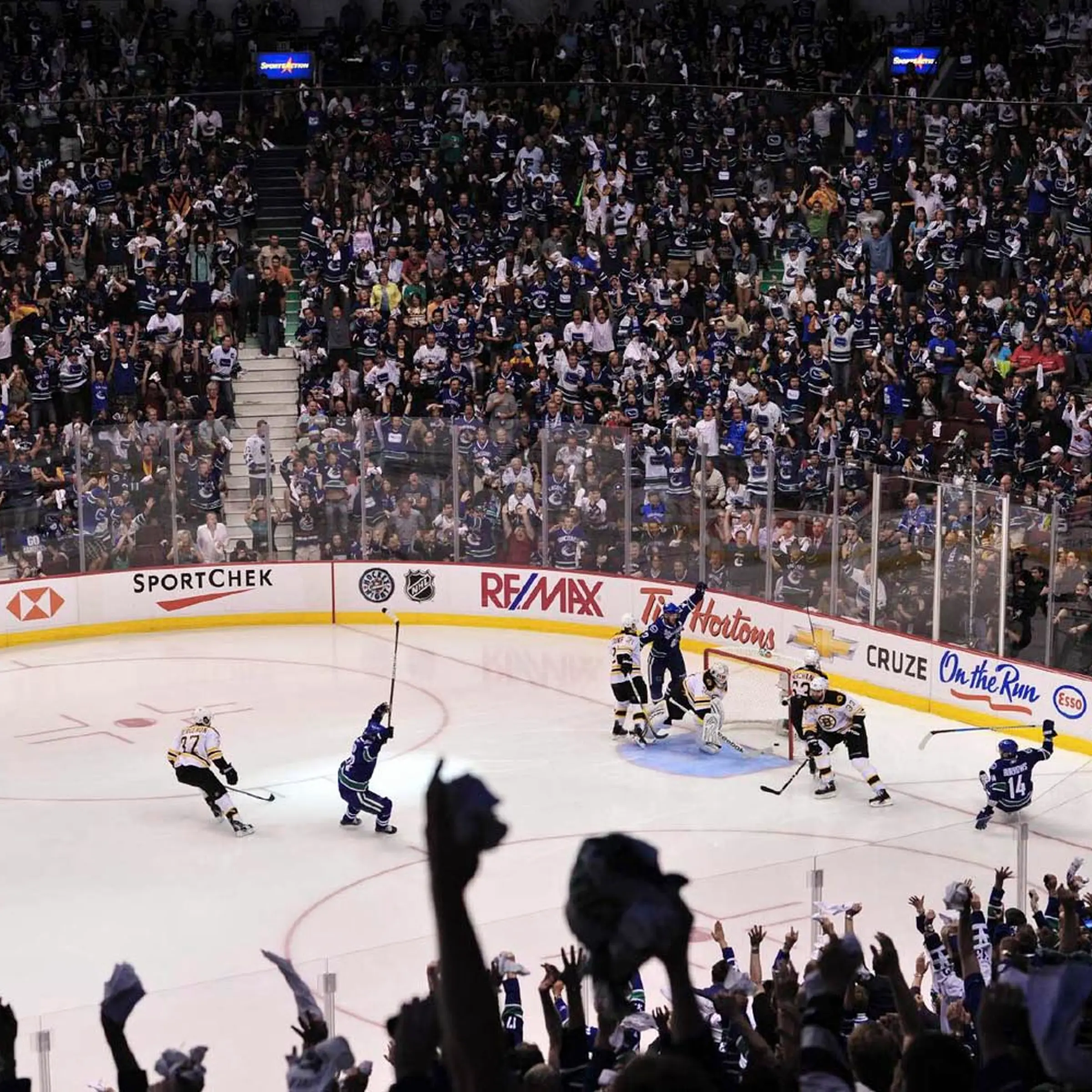 Fans and Canucks players erupt in cheers after Alexandre Burrows (14) scores the game-winning goal 11 seconds into overtime in game two of the Stanley Cup Finals.