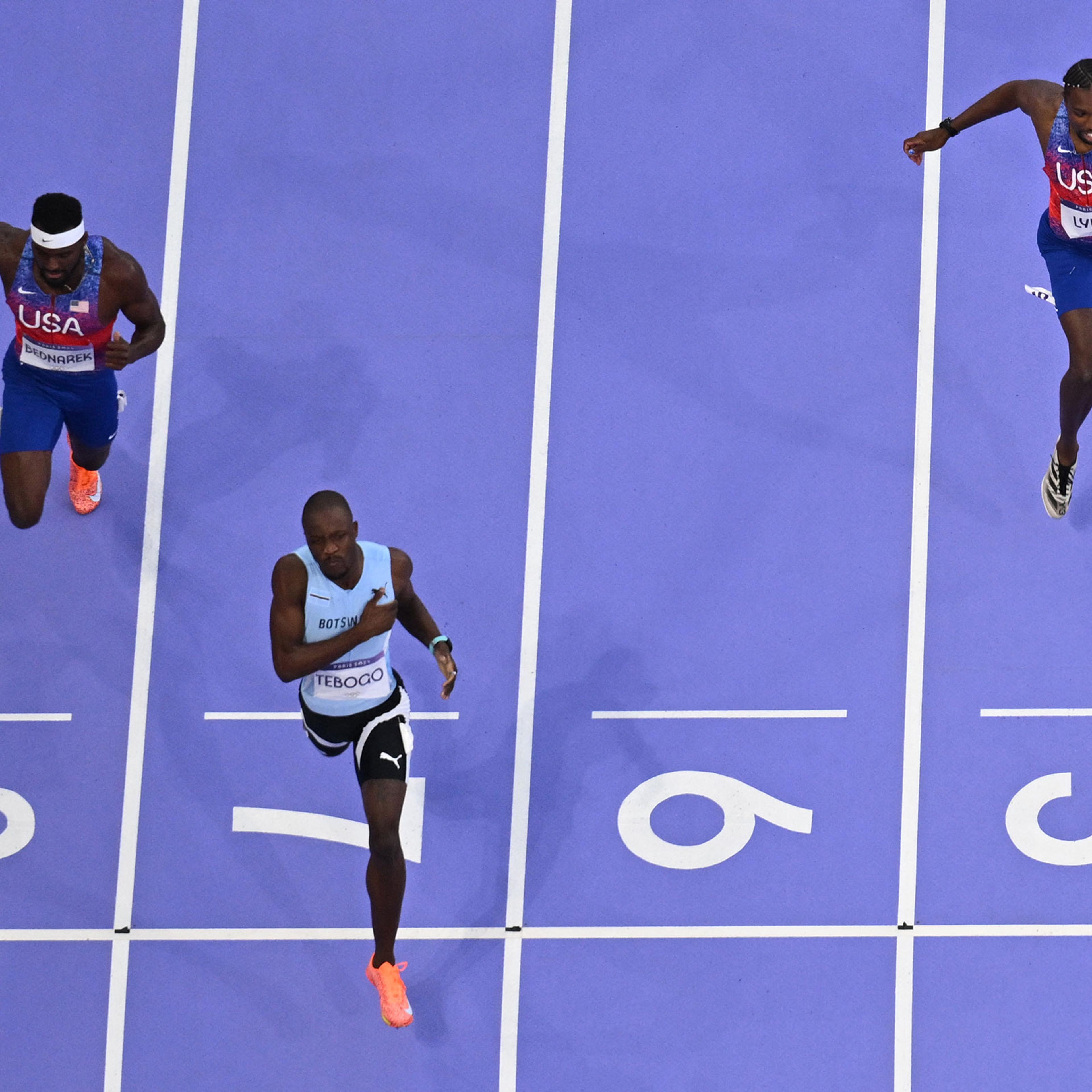 Botswana's Letsile Tebogo crosses the finish line ahead of US' Kenny Bednarek and Noah Lyles to win the men's 200m final of the athletics event at the Paris 2024 Olympic Games on Aug. 8, 2024.