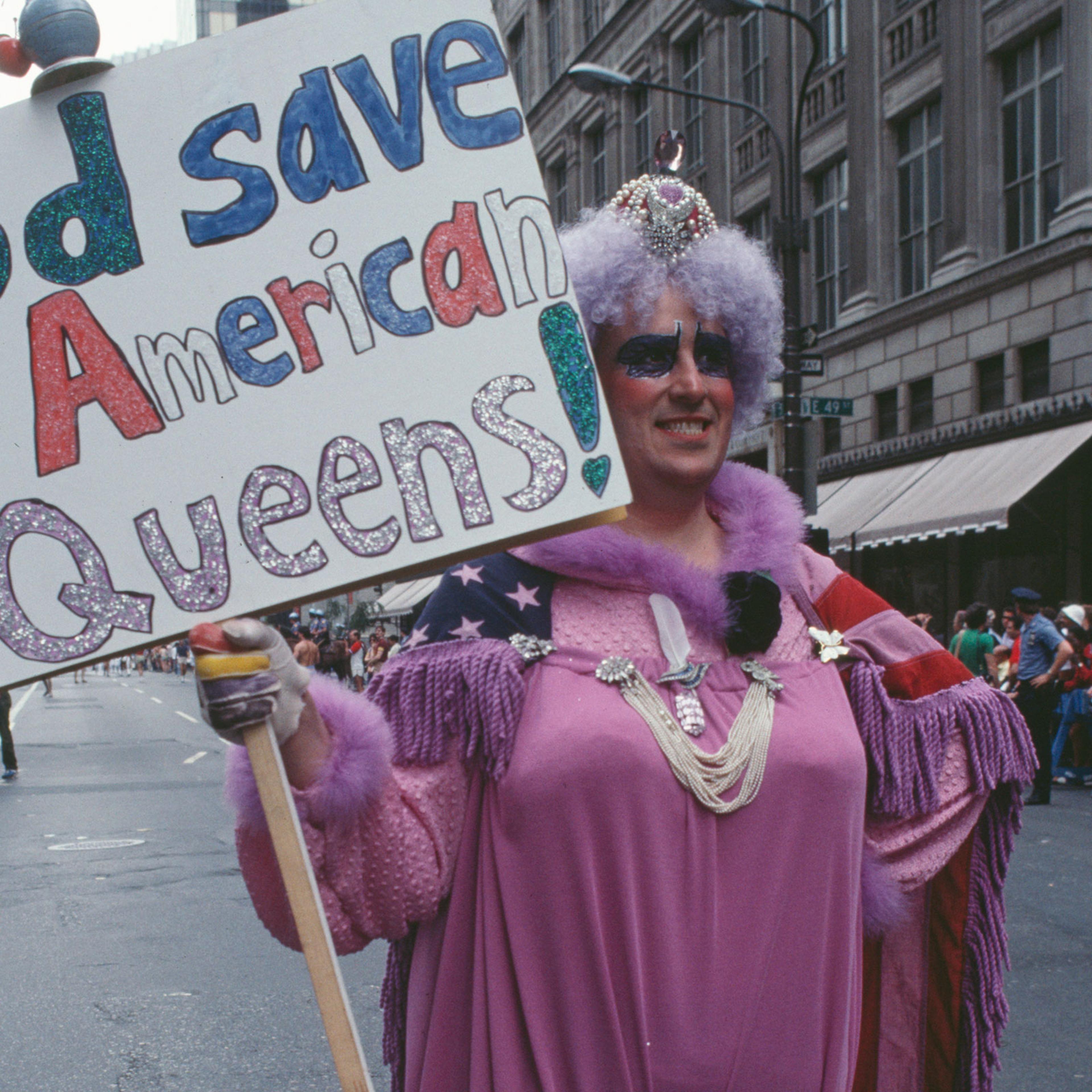 A drag queen holding a placard reading 'God save the American queens!' during the Pride Parade in New York City, June 1983.