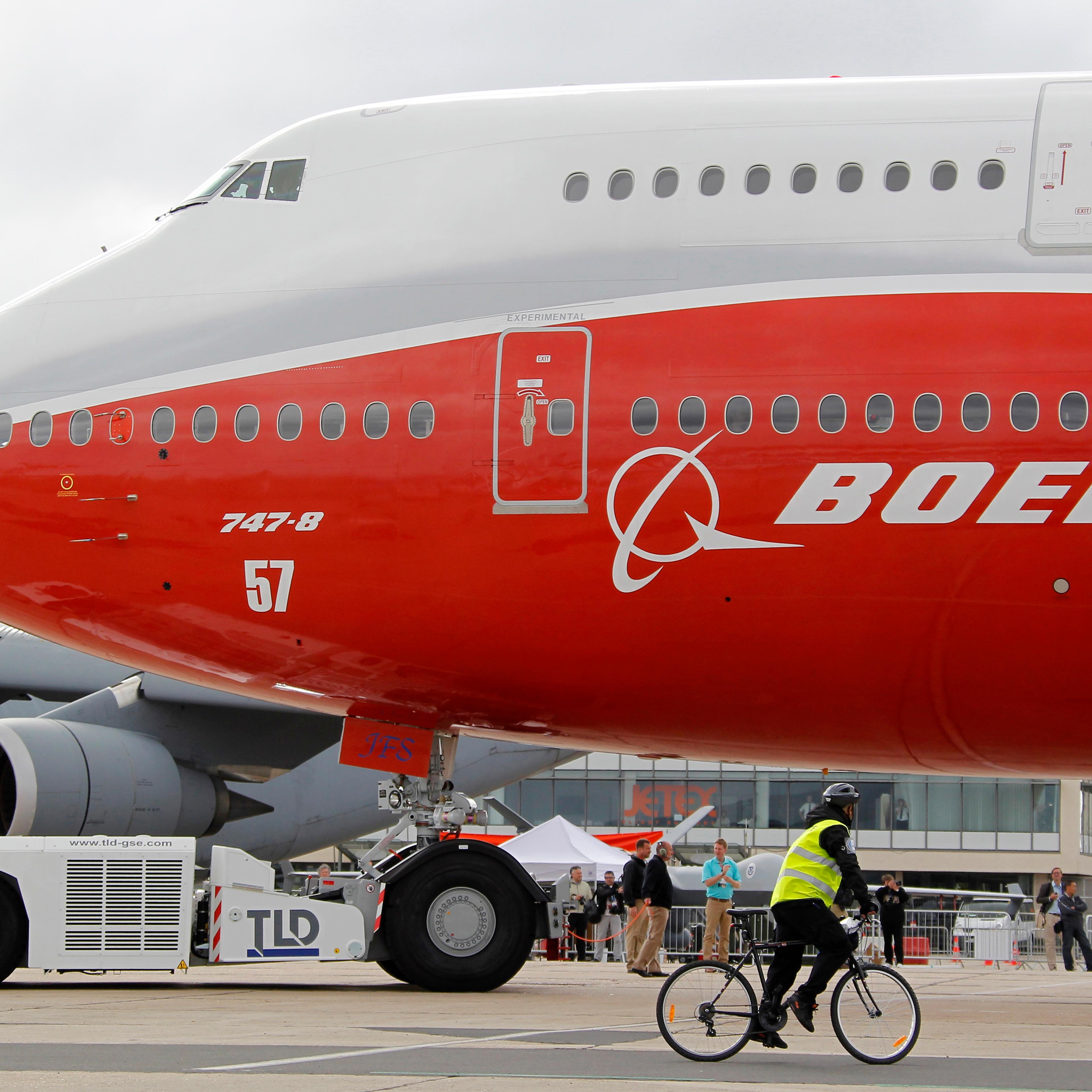 Workers move the new Boeing 747-8 Intercontinental jetliner into a static display on the eve of the Paris Air Show at Le Bourget airport