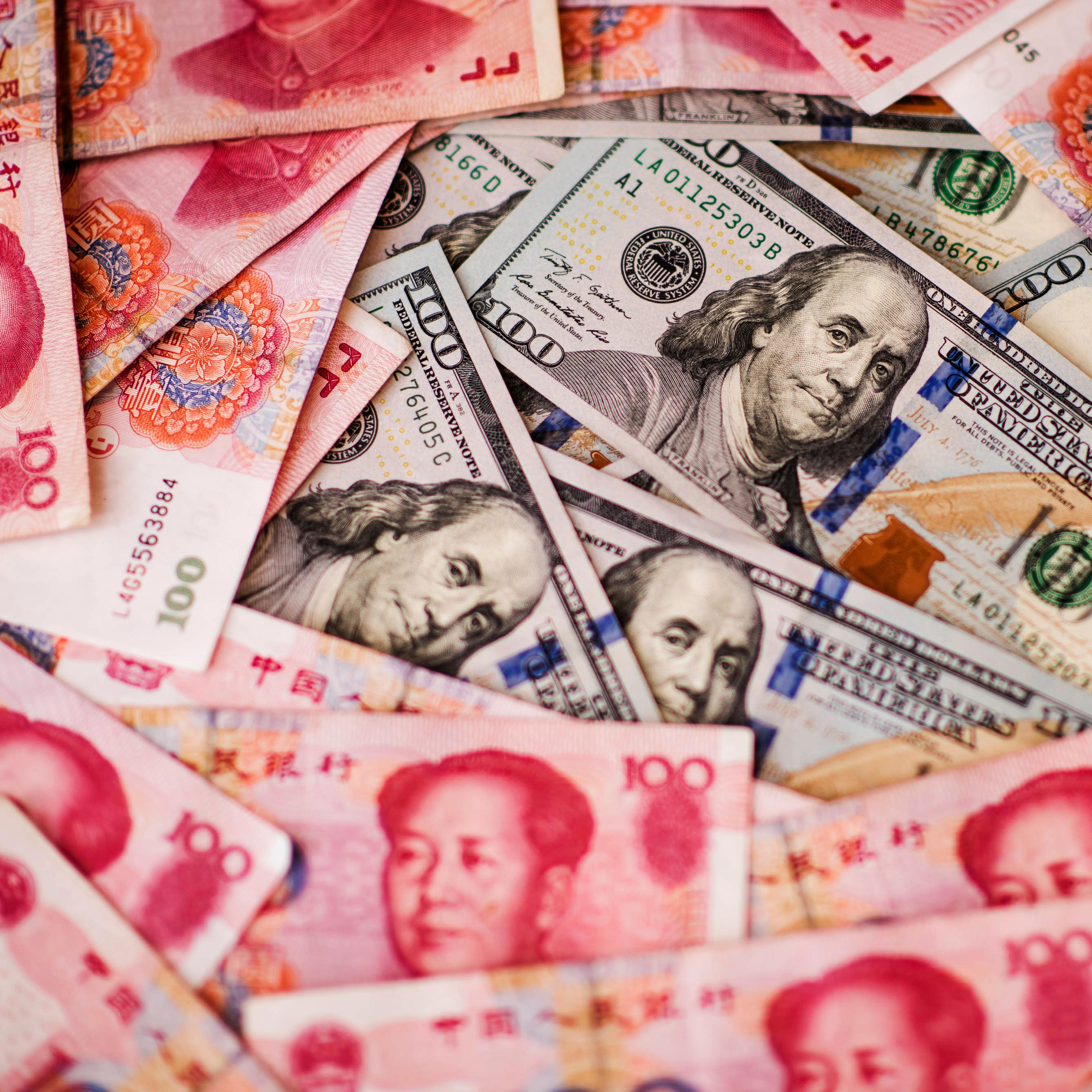 U.S. one-hundred dollar bills and Chinese one-hundred yuan banknotes are arranged for a photograph in Hong Kong, China, on Monday, July 20, 2015.