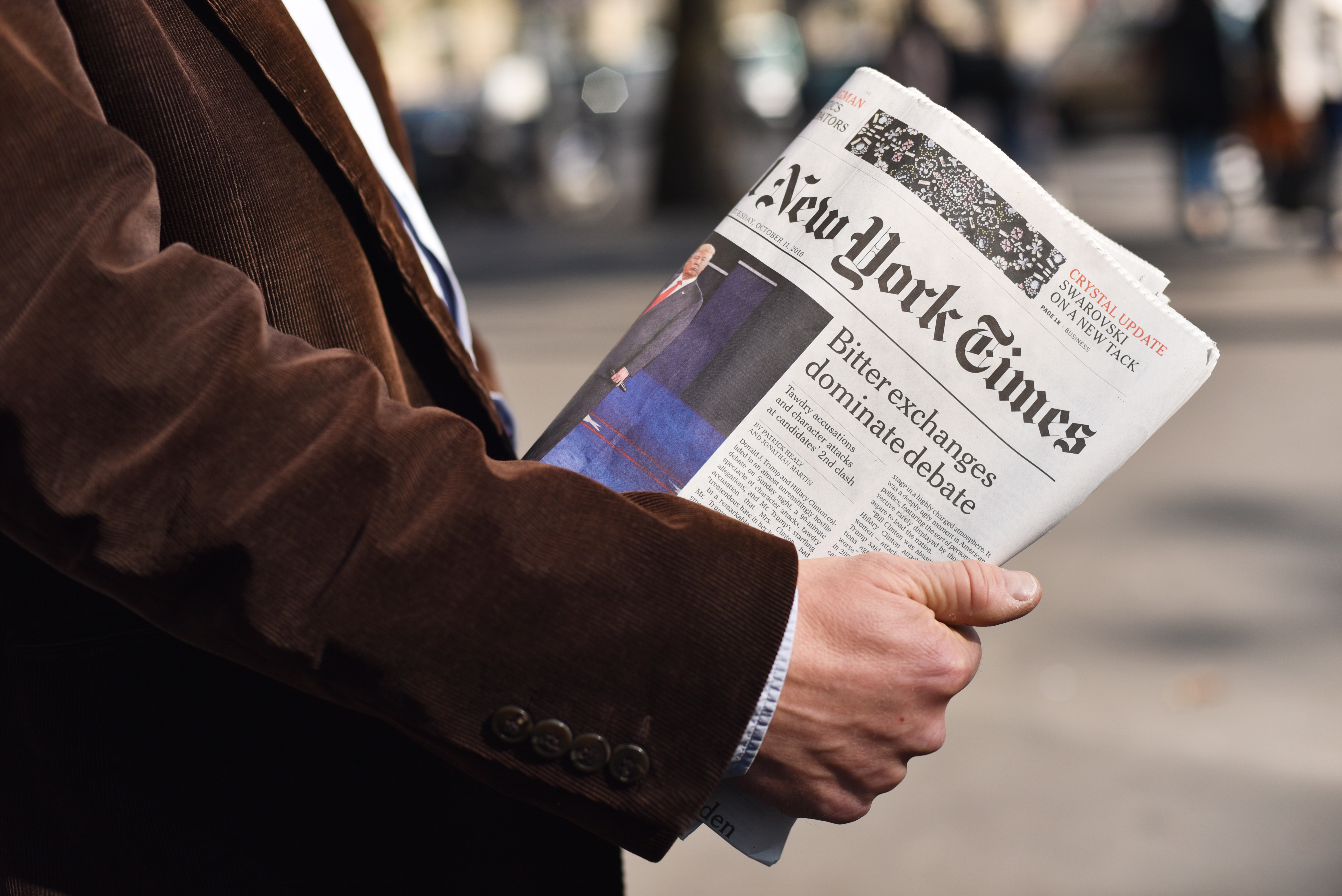 Man holding the New York Times in his hand.