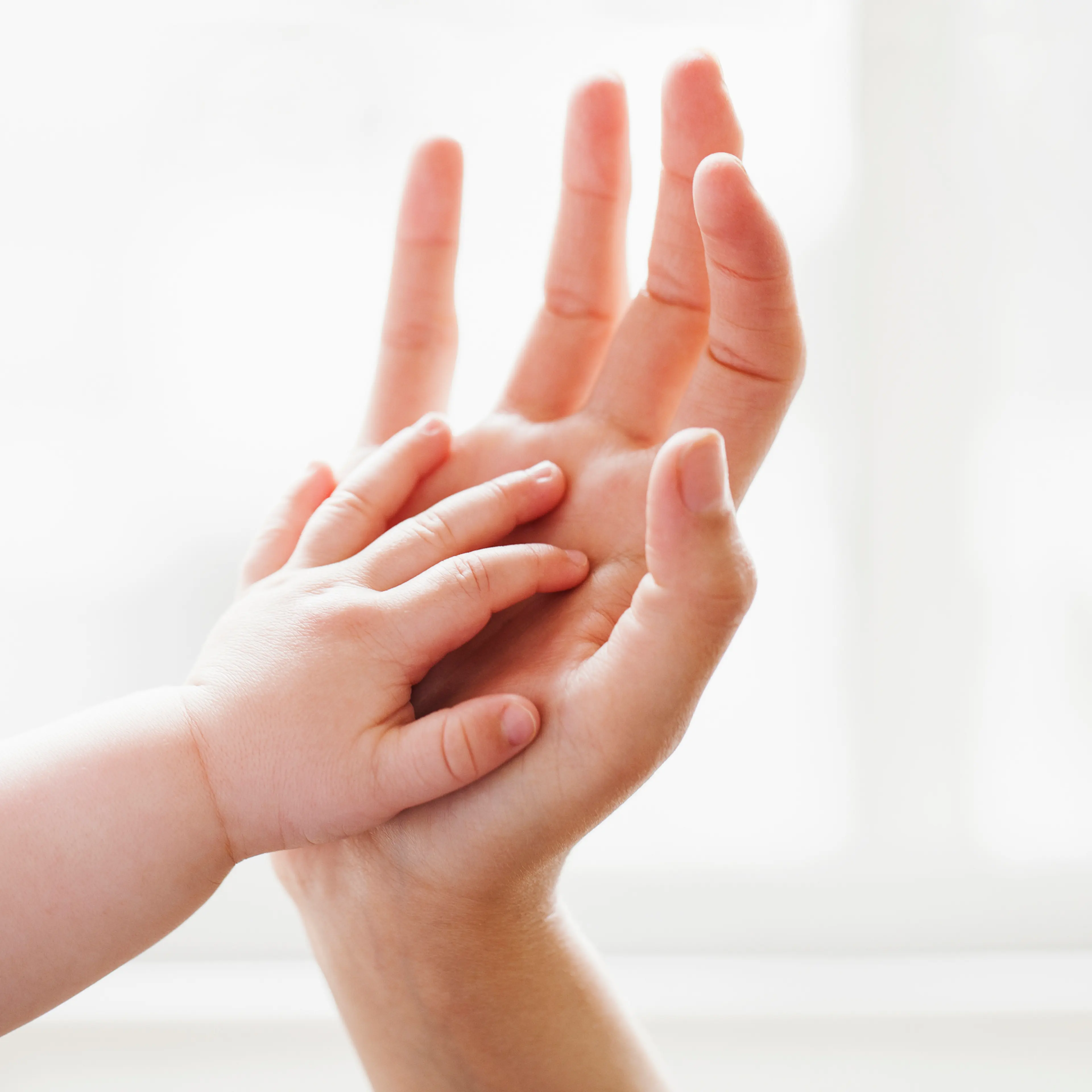 Baby touching mother's hand