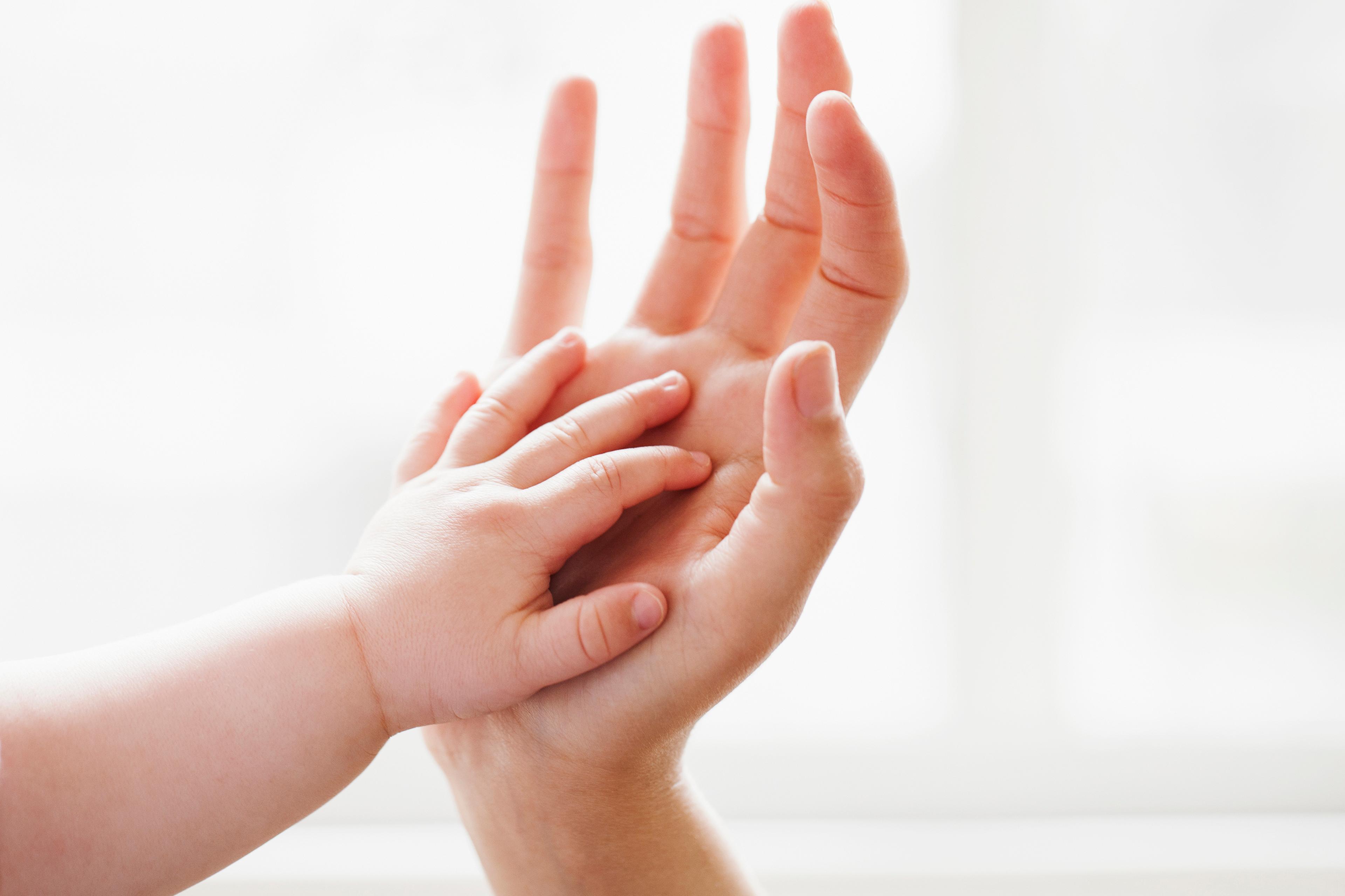 Baby touching mother's hand