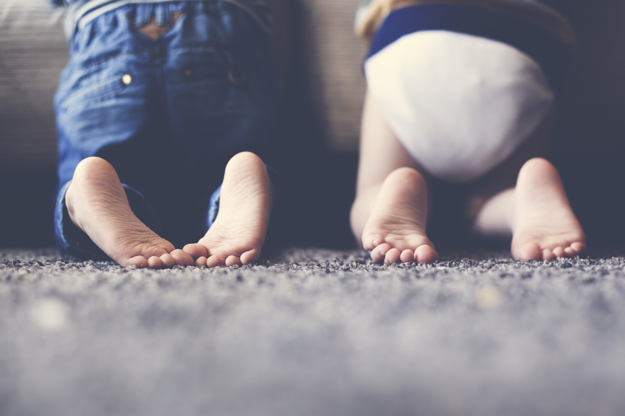 Photograph of the feet of two twin brothers playing together