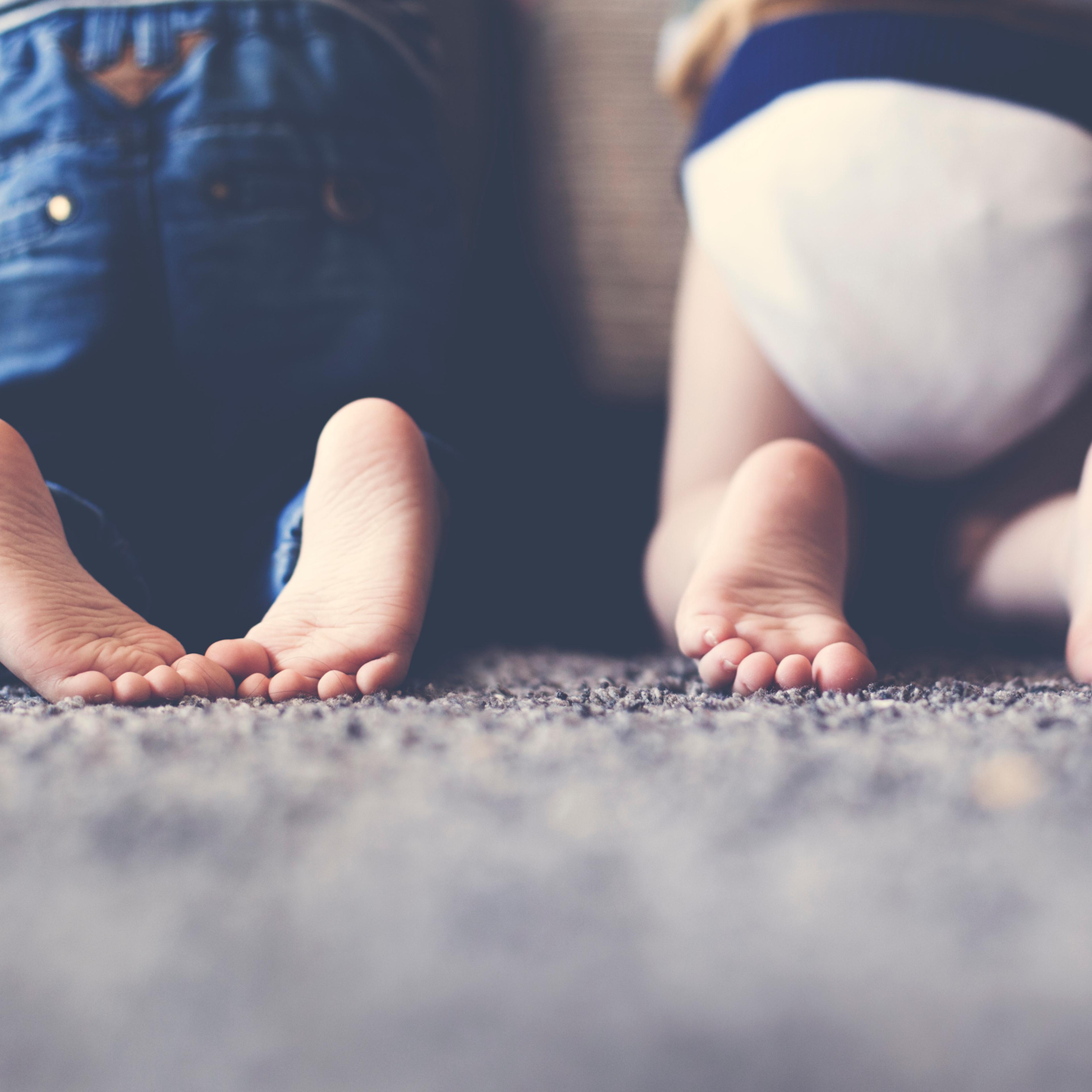 Photograph of the feet of two twin brothers playing together