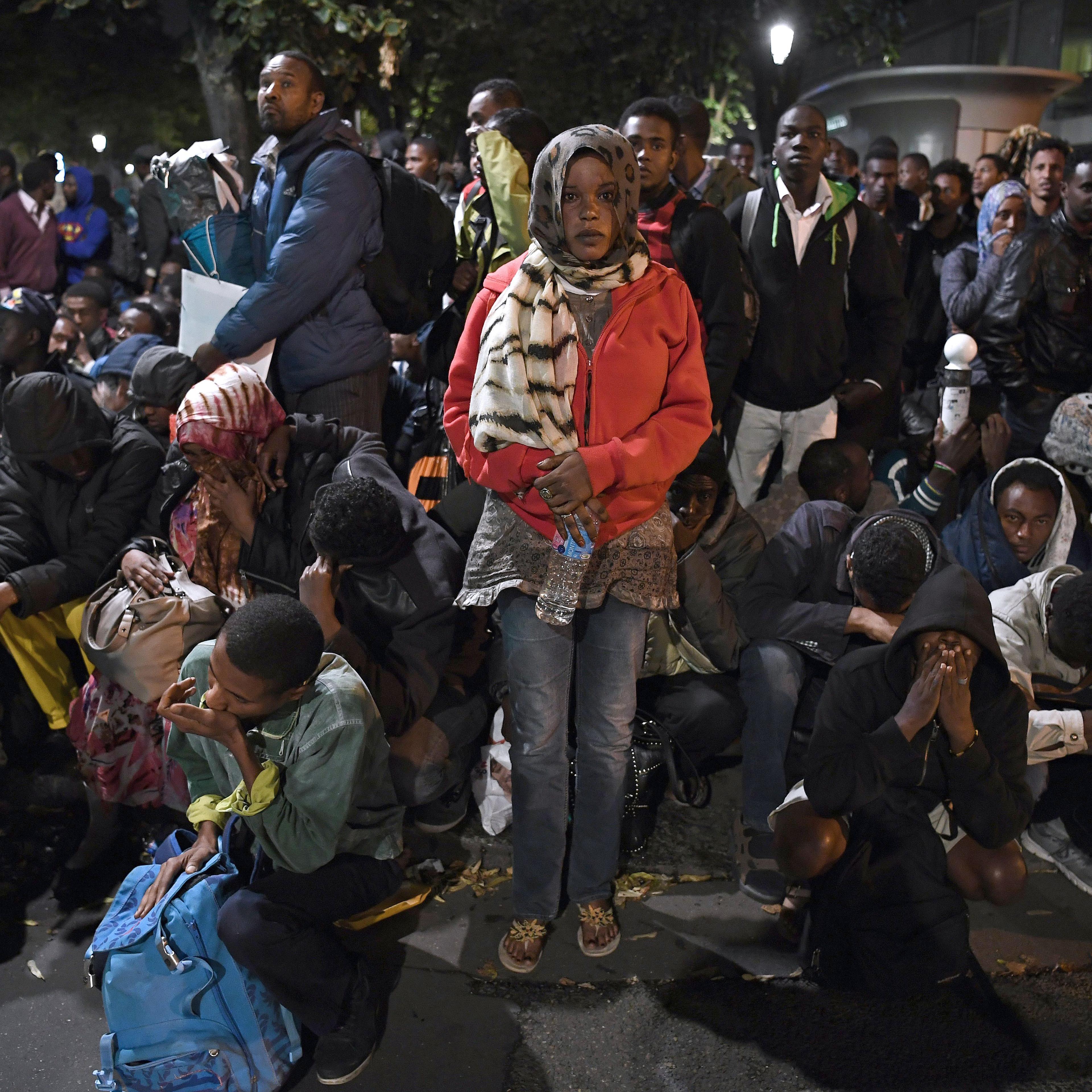 Migrants gather and wait before being evacuated from a makeshift migrant camp set up between the metro stations of Jaures and Stalingrad, in Paris on Sept. 16, 2016.
