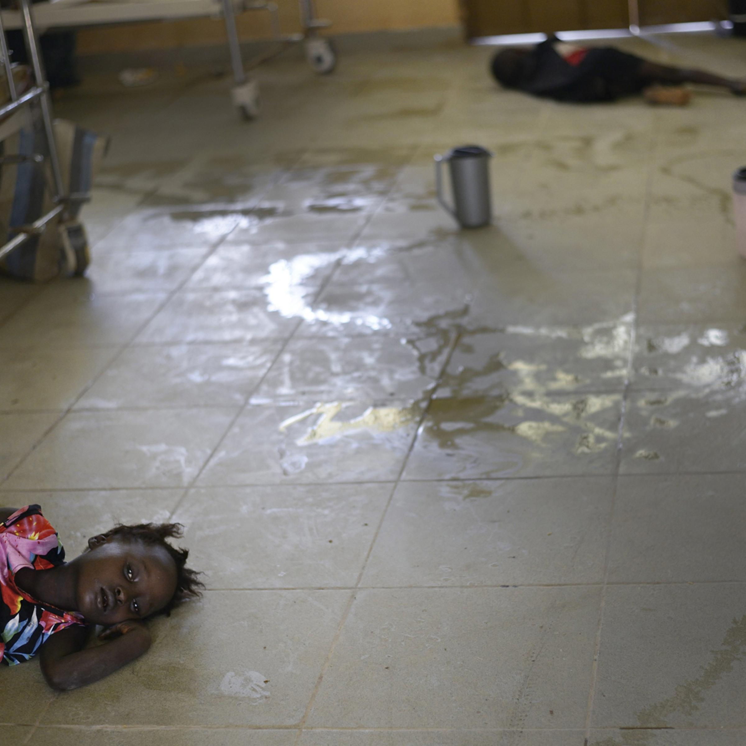 Mariattu Kanu, 4, who is suspected of being infected with Ebola, lies on the floor amid body fluids in a ward for Ebola victims at a hospital in Makeni, Sierra Leone, Sept. 27, 2014.