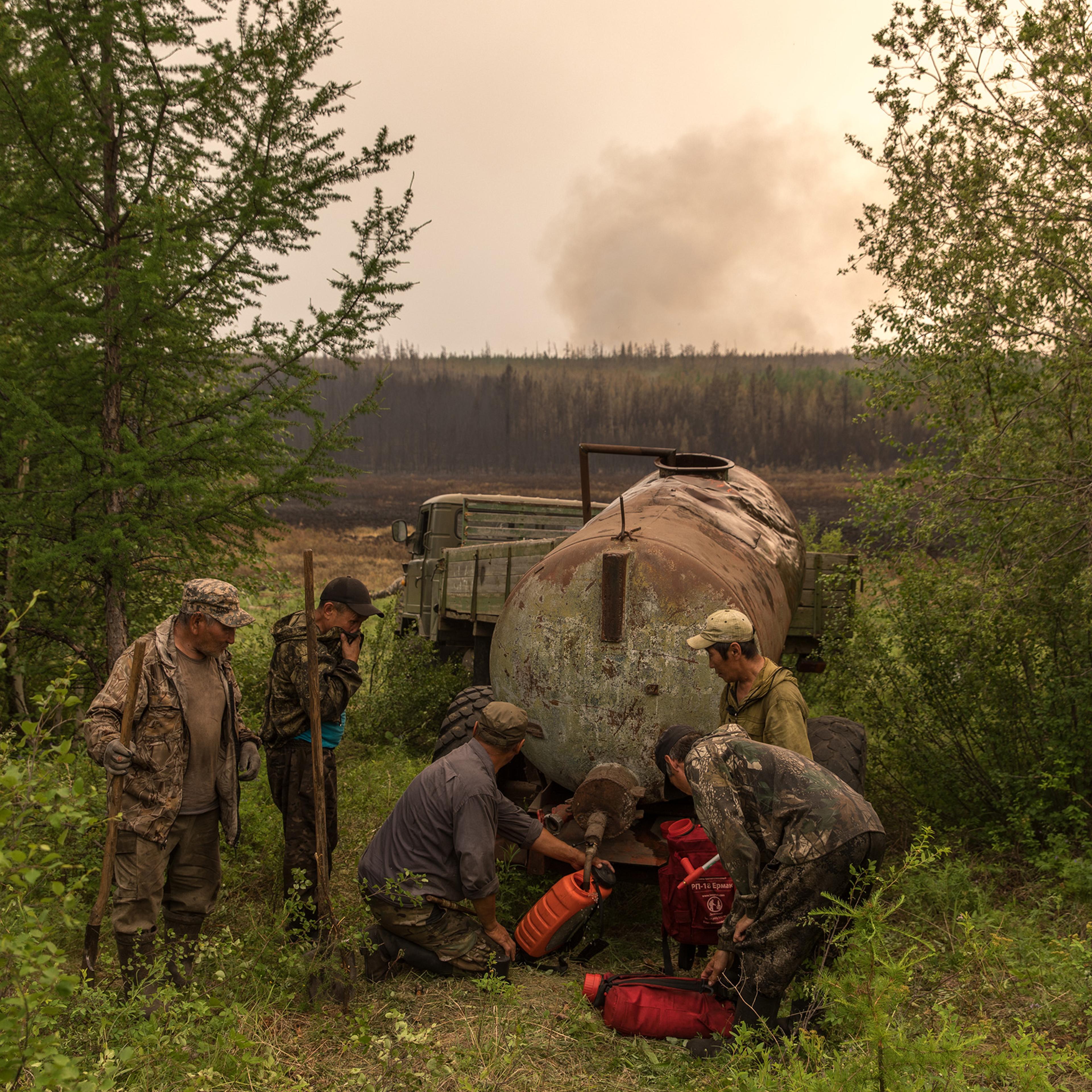 Volunteers fill satchels with water to battle fires near their homes in Magaras, a village in eastern Russia.