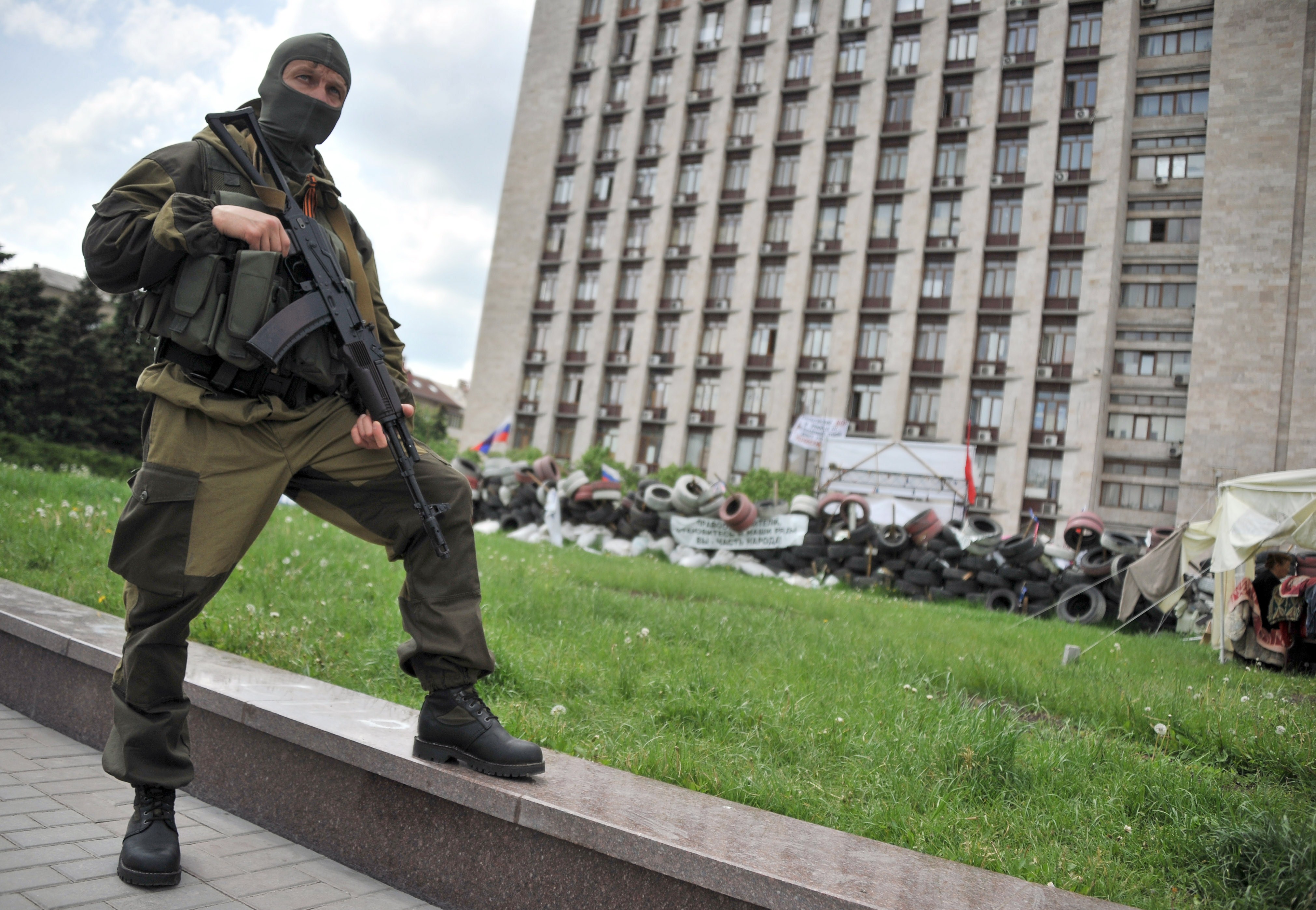 An armed pro-Russia militant stands guard as the self-styled governor of the so-called "People's Republic of Donetsk" speaks to the media near the regional state building seized by separatists in the centre of the eastern Ukrainian city of Donetsk on May