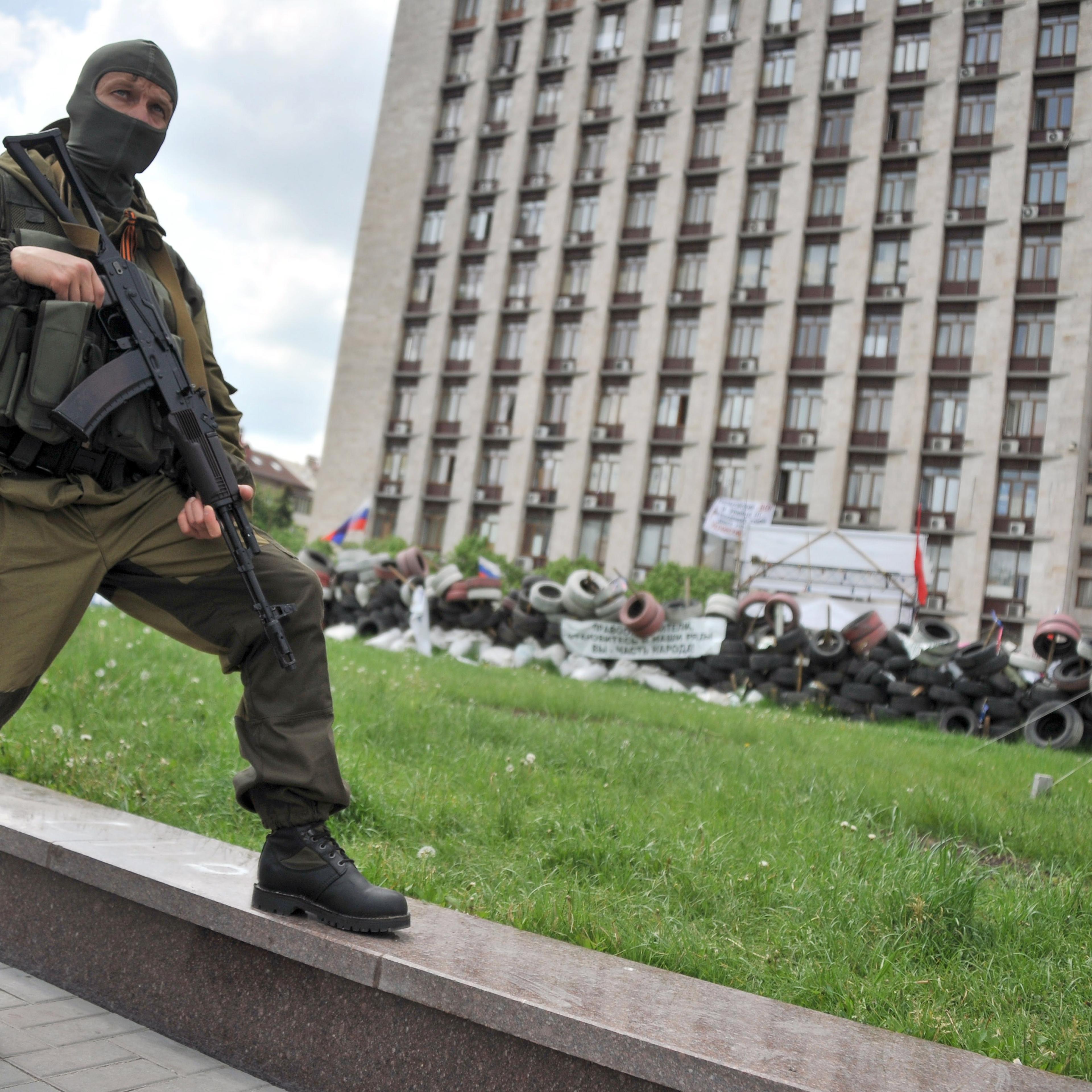 An armed pro-Russia militant stands guard as the self-styled governor of the so-called "People's Republic of Donetsk" speaks to the media near the regional state building seized by separatists in the centre of the eastern Ukrainian city of Donetsk on May