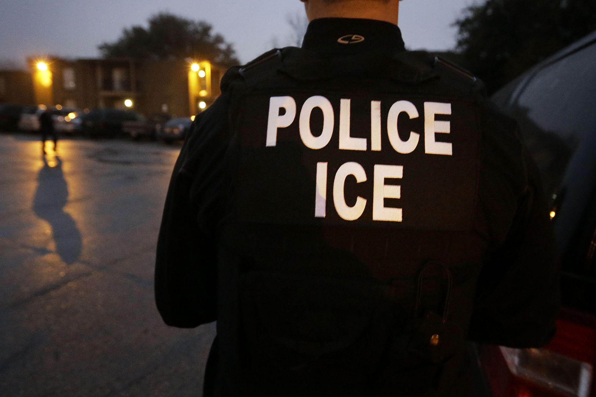 In this photo made March 6, 2015, U.S. Immigration and Customs Enforcement agents enter an apartment complex looking for a specific undocumented immigrant convicted of a felony during an early morning operation in Dallas.