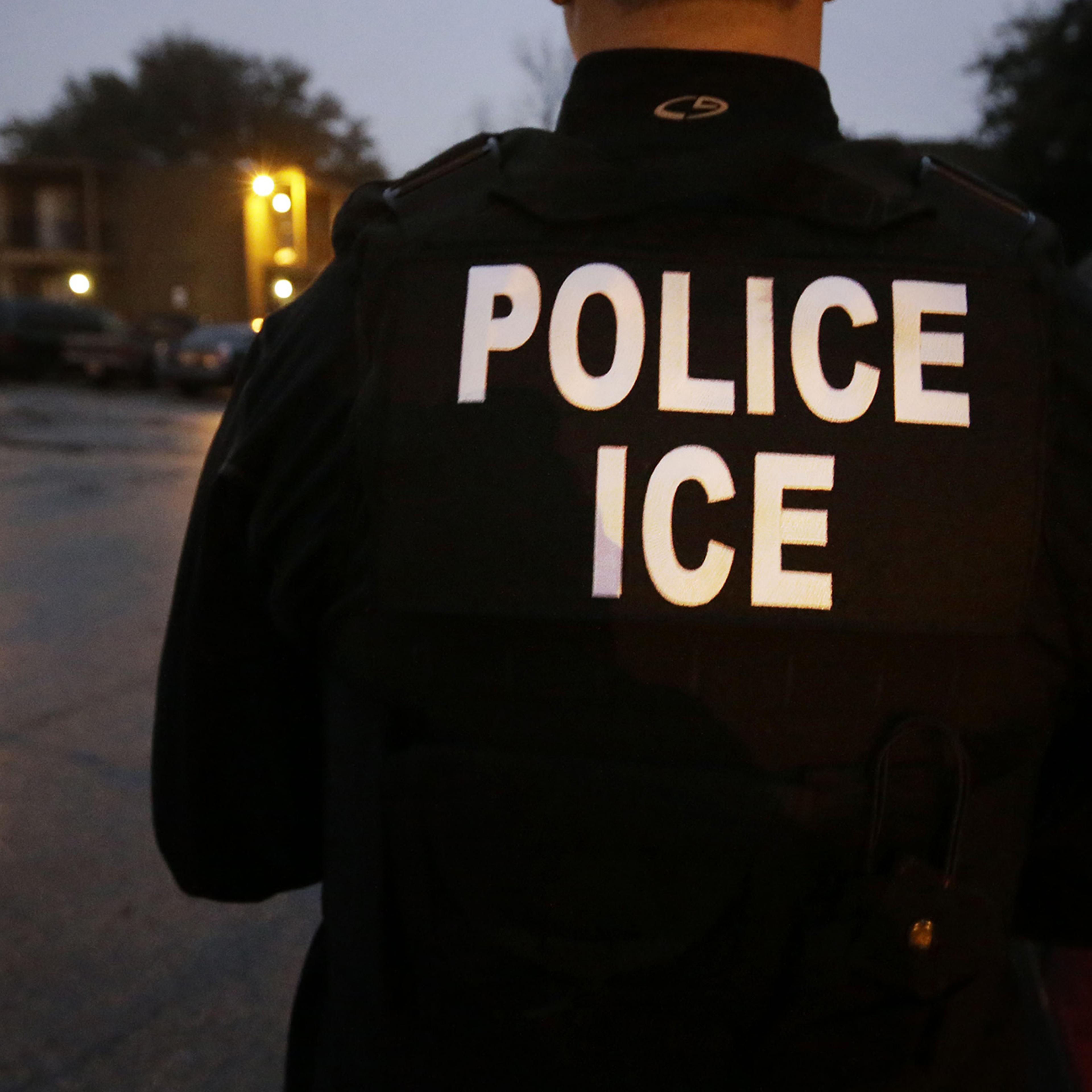 In this photo made March 6, 2015, U.S. Immigration and Customs Enforcement agents enter an apartment complex looking for a specific undocumented immigrant convicted of a felony during an early morning operation in Dallas.