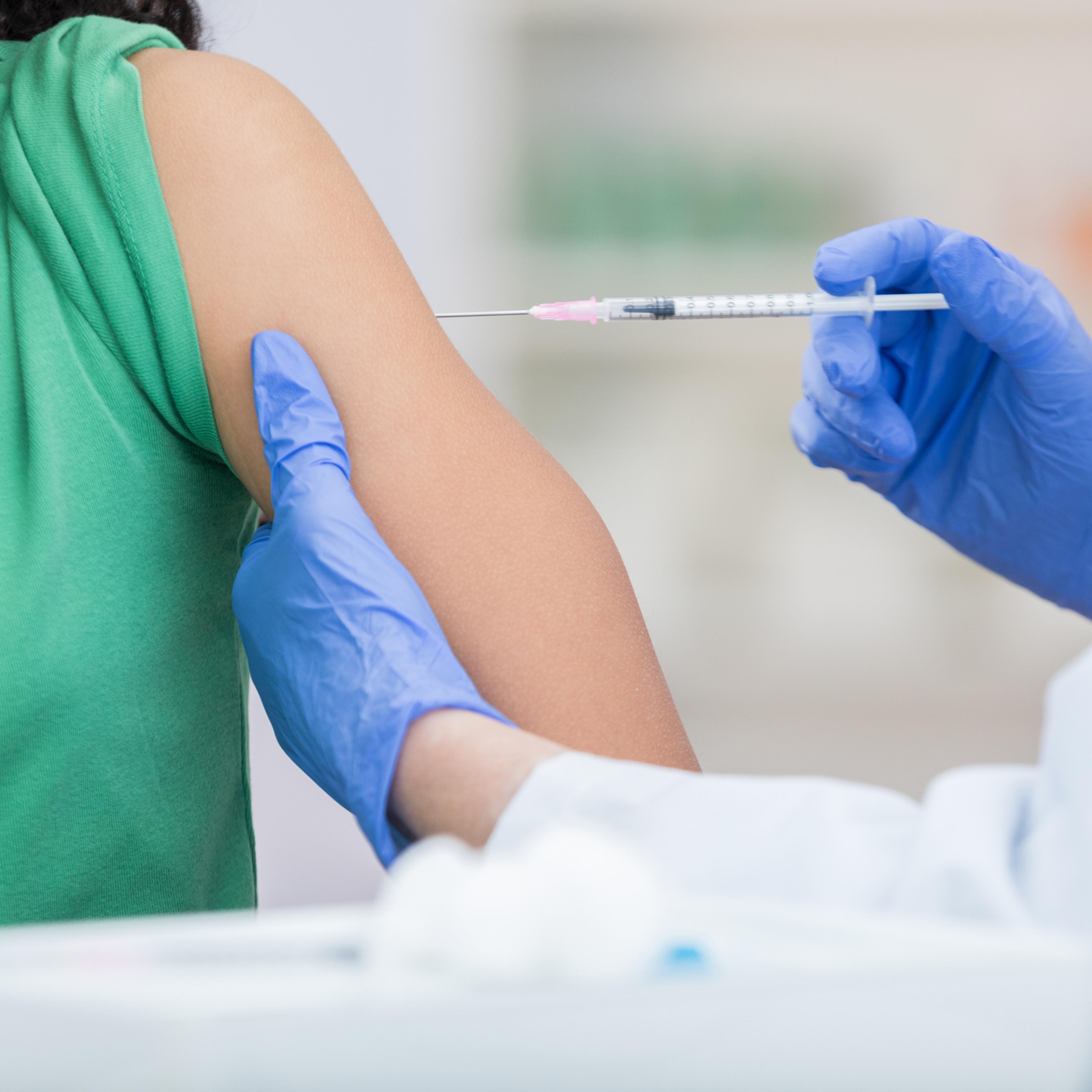 Unrecognizable girl receives flu shot