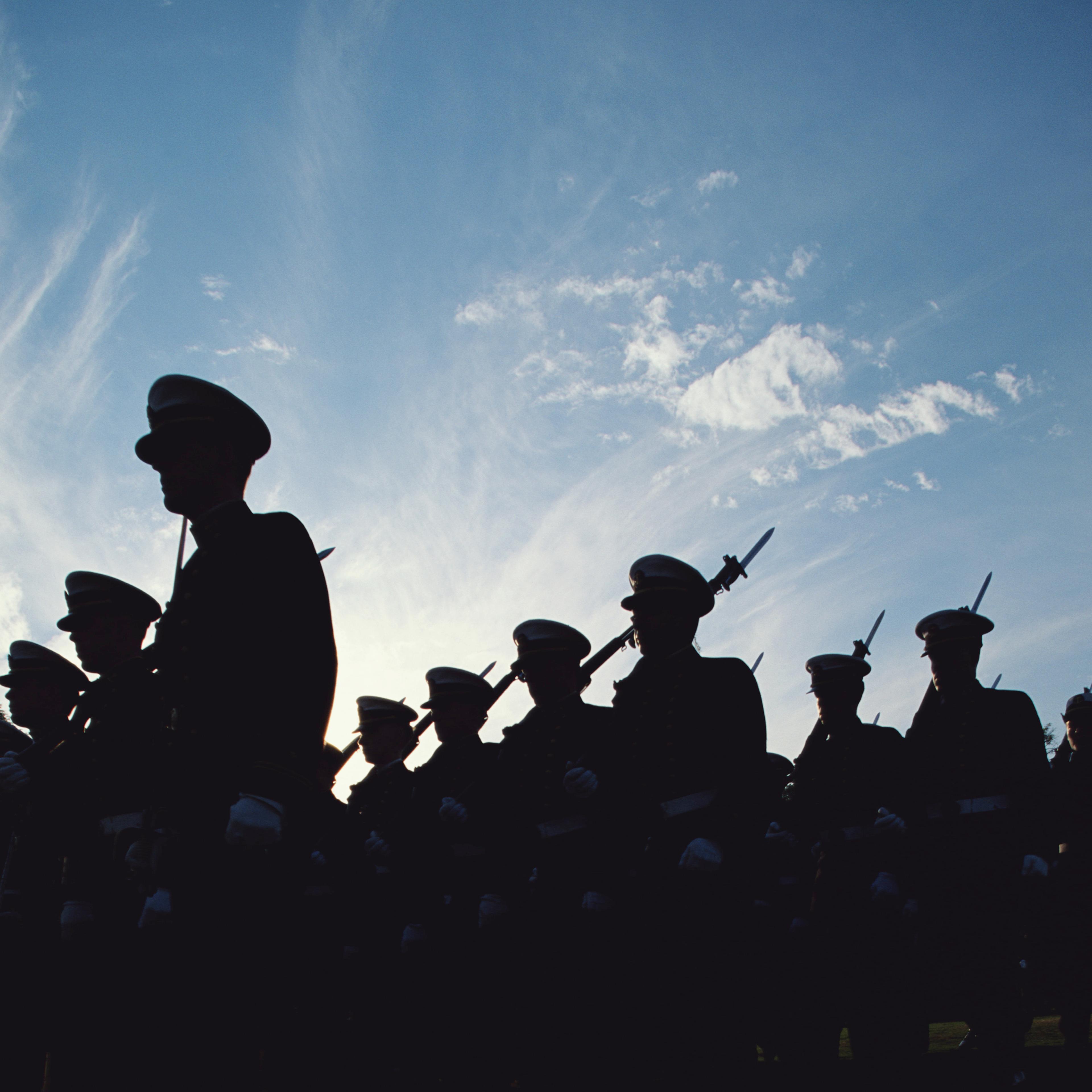 Silhouetted naval cadets marching in formation, low angle view