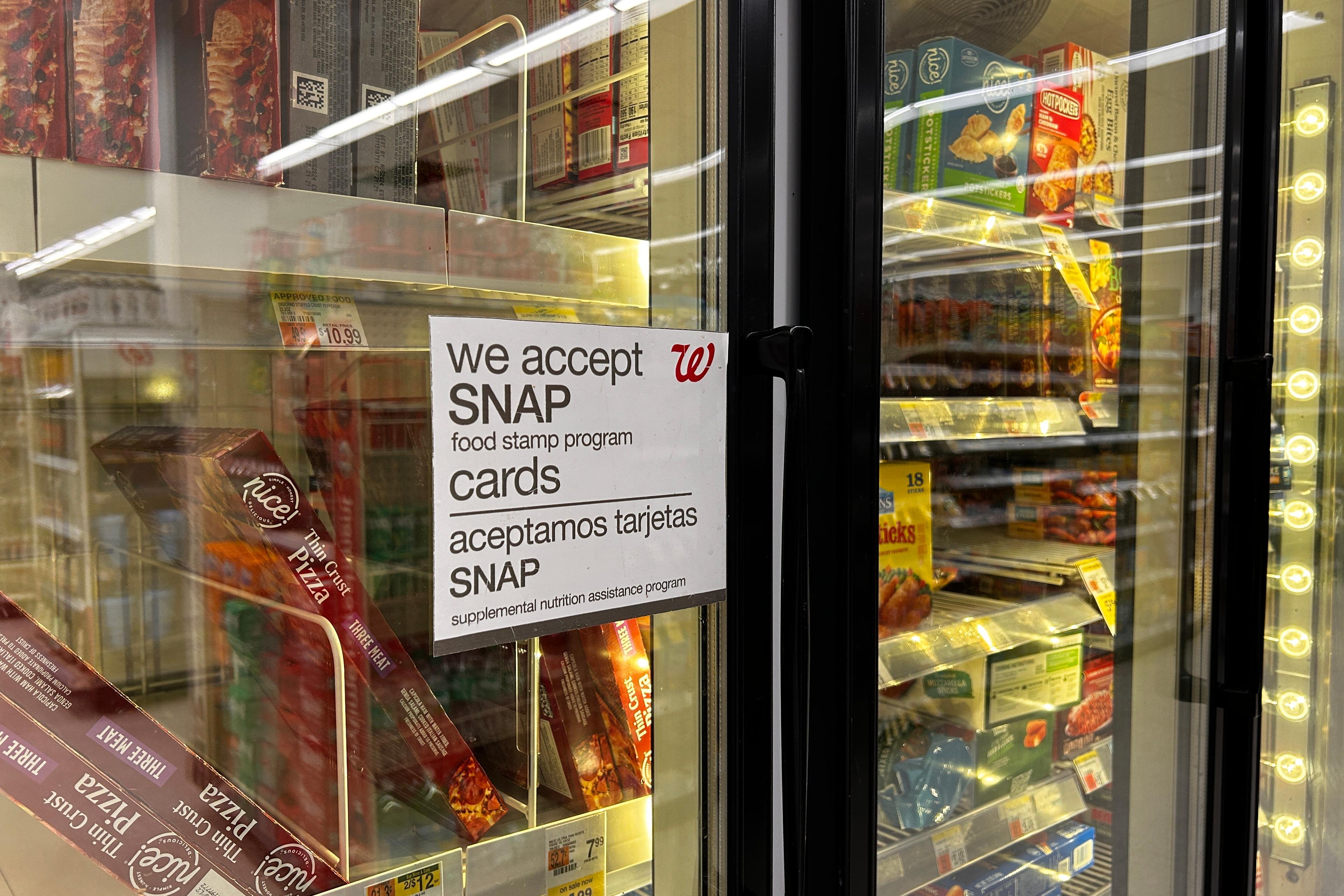 Bilingual sign on door of frozen food aisle, We accept SNAP food stamp cards, Walgreens, Queens, New York