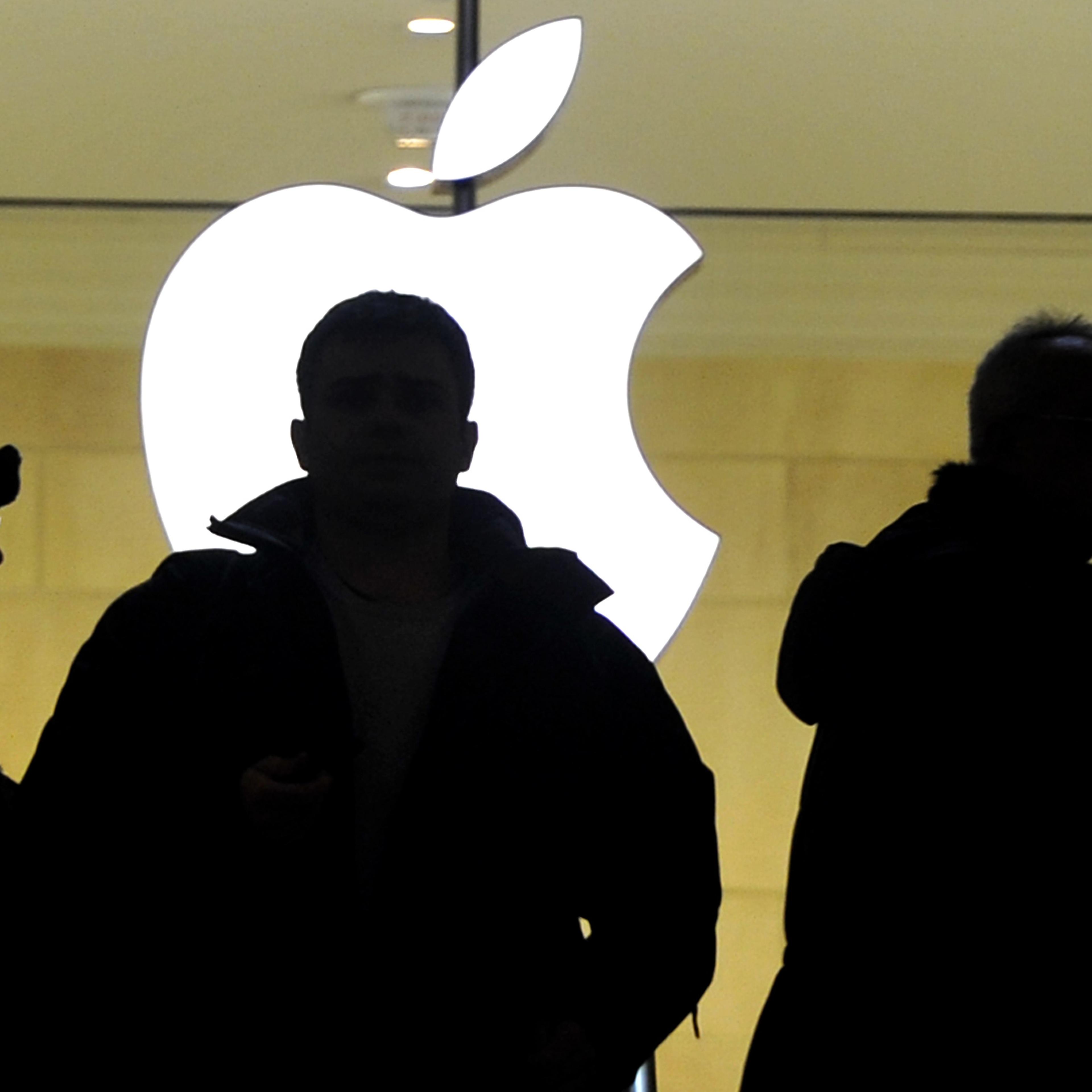 People walk past the Apple logo at the Apple Store at Grand Central Terminal in New York.