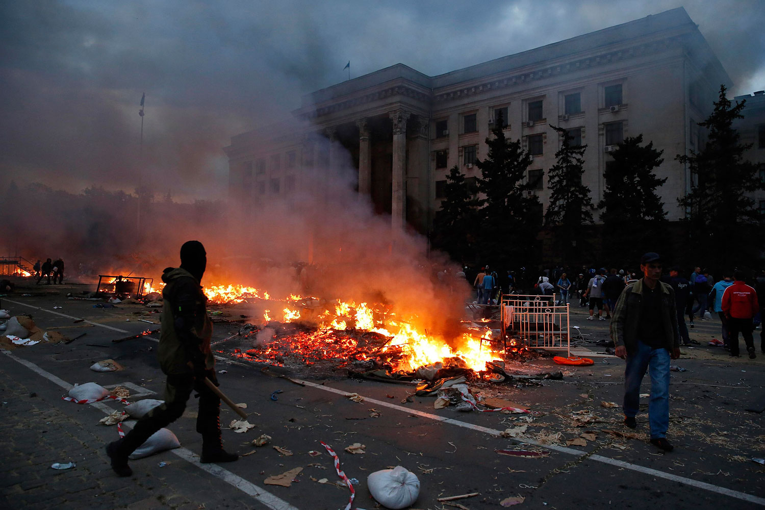 A protester walks past a burning pro-Russian tent camp near the trade union building in Odessa