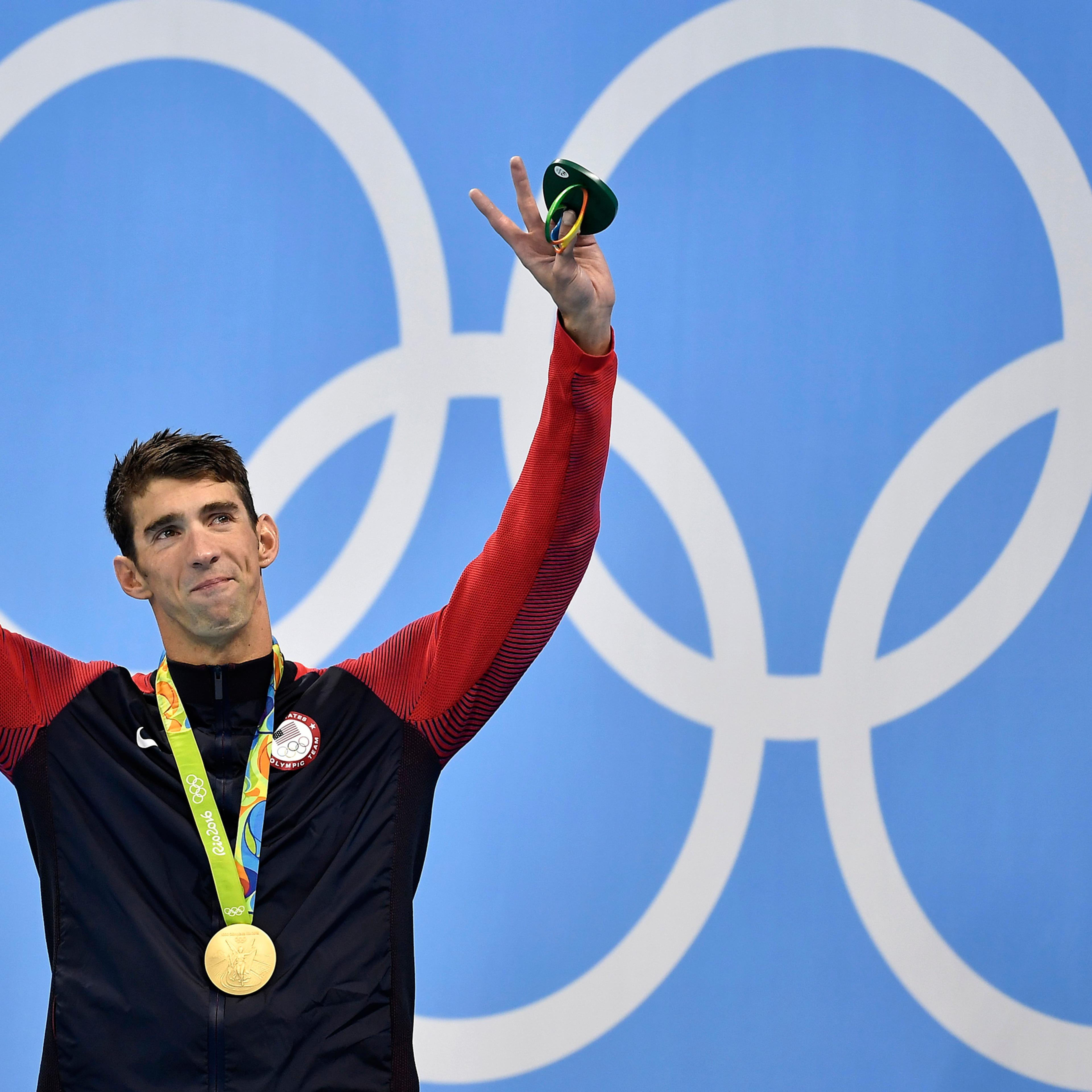 United States' Michael Phelps celebrates after he was awarded the gold medal during the medal ceremony for the men's 200-meter individual medley final during the swimming competitions at the 2016 Summer Olympics, Thursday, Aug. 11, 2016, in Rio de Janeir