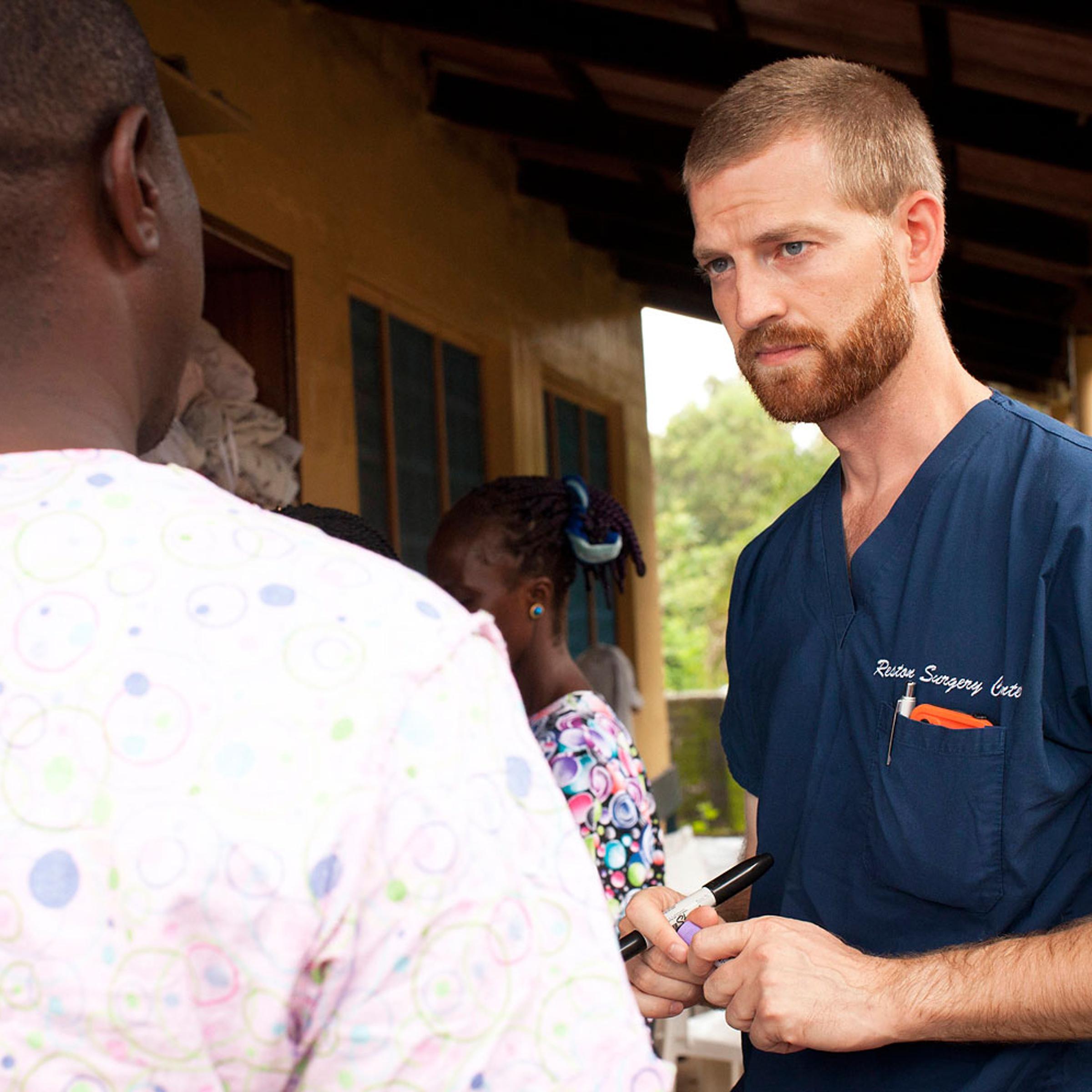 Handout photo of Dr. Kent Brantly speaking with colleagues at the case management center on the campus of ELWA Hospital in Monrovia