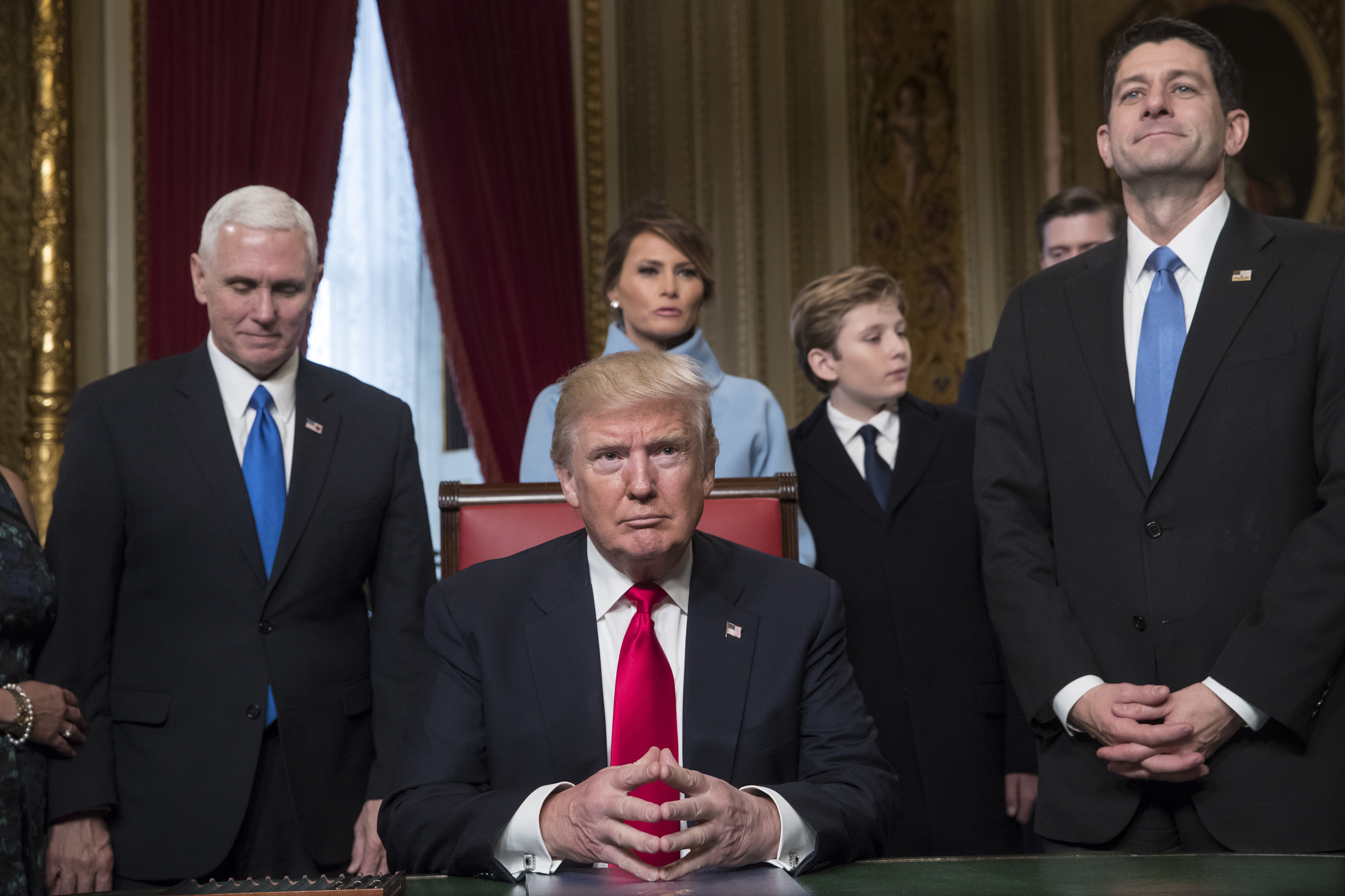 U.S. President Donald Trump, center, sits before formally signing his cabinet nominations into law with Vice President Mike Pence, left, and U.S. House Speaker Paul Ryan, a Republican from Wisconsin, during the 58th presidential inauguration in Washingto