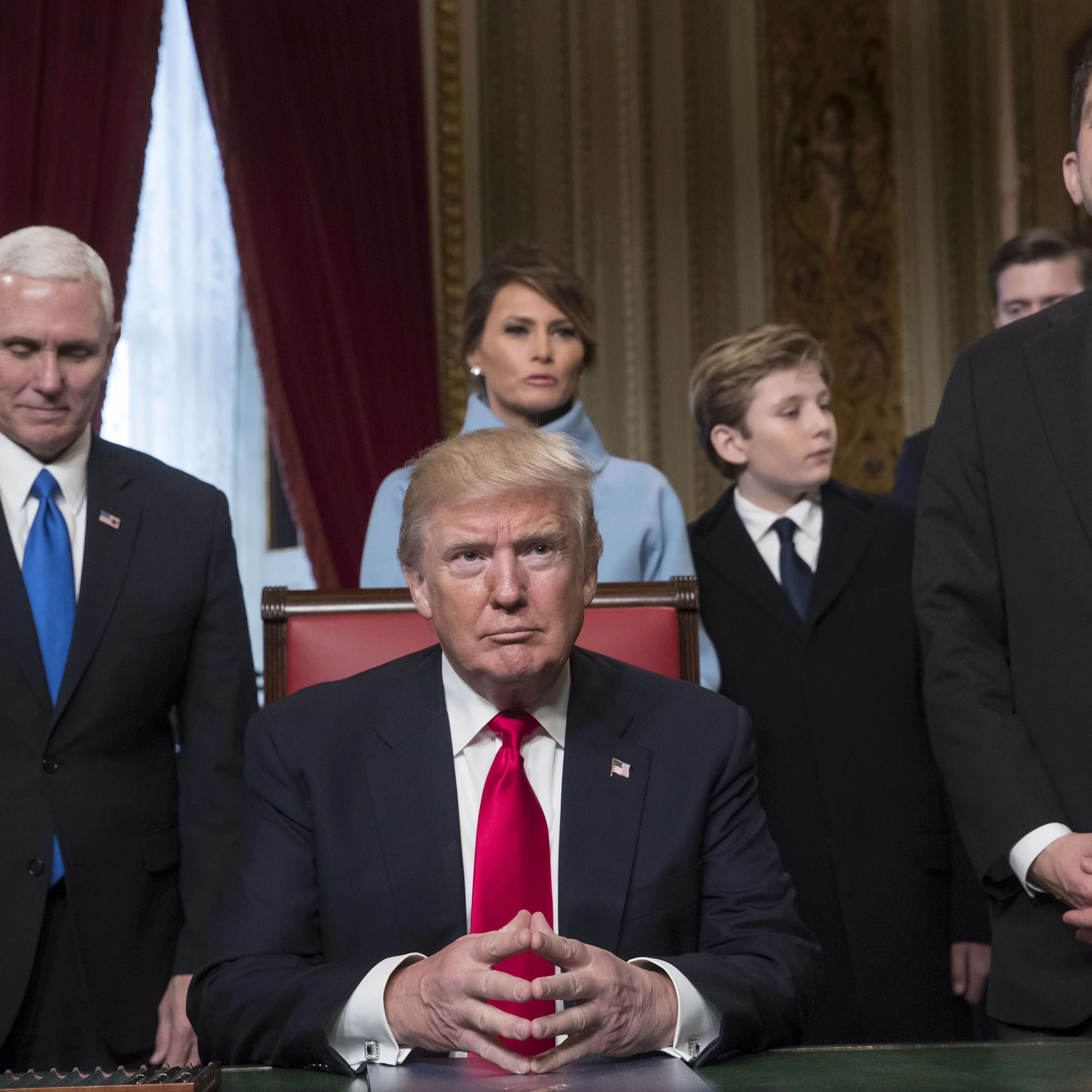 U.S. President Donald Trump, center, sits before formally signing his cabinet nominations into law with Vice President Mike Pence, left, and U.S. House Speaker Paul Ryan, a Republican from Wisconsin, during the 58th presidential inauguration in Washingto