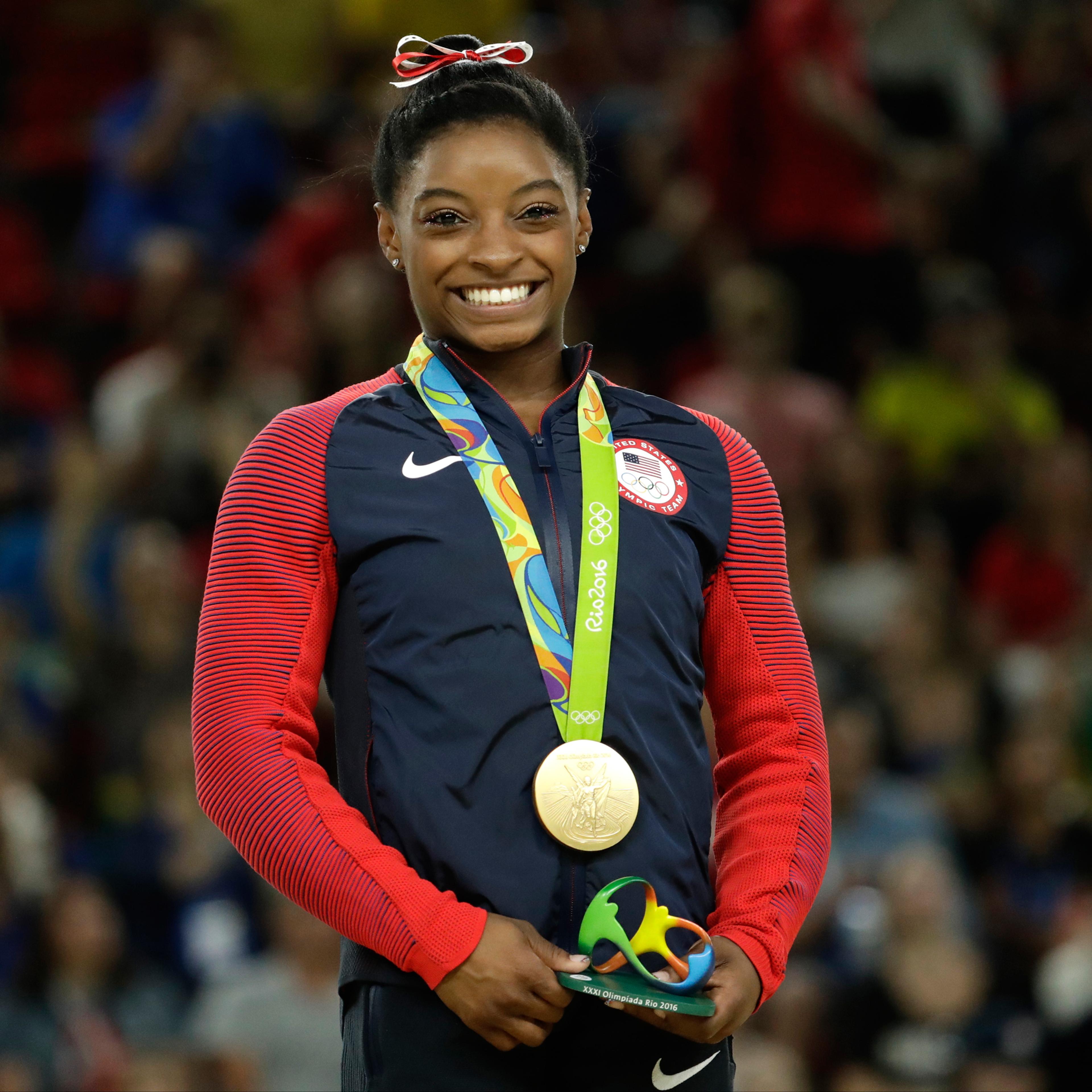 United States' Simone Biles smiles on the podium after winning vault gold during the artistic gymnastics women's apparatus final at the 2016 Summer Olympics in Rio de Janeiro, Brazil, Sunday, Aug. 14, 2016. (AP Photo/Dmitri Lovetsky)