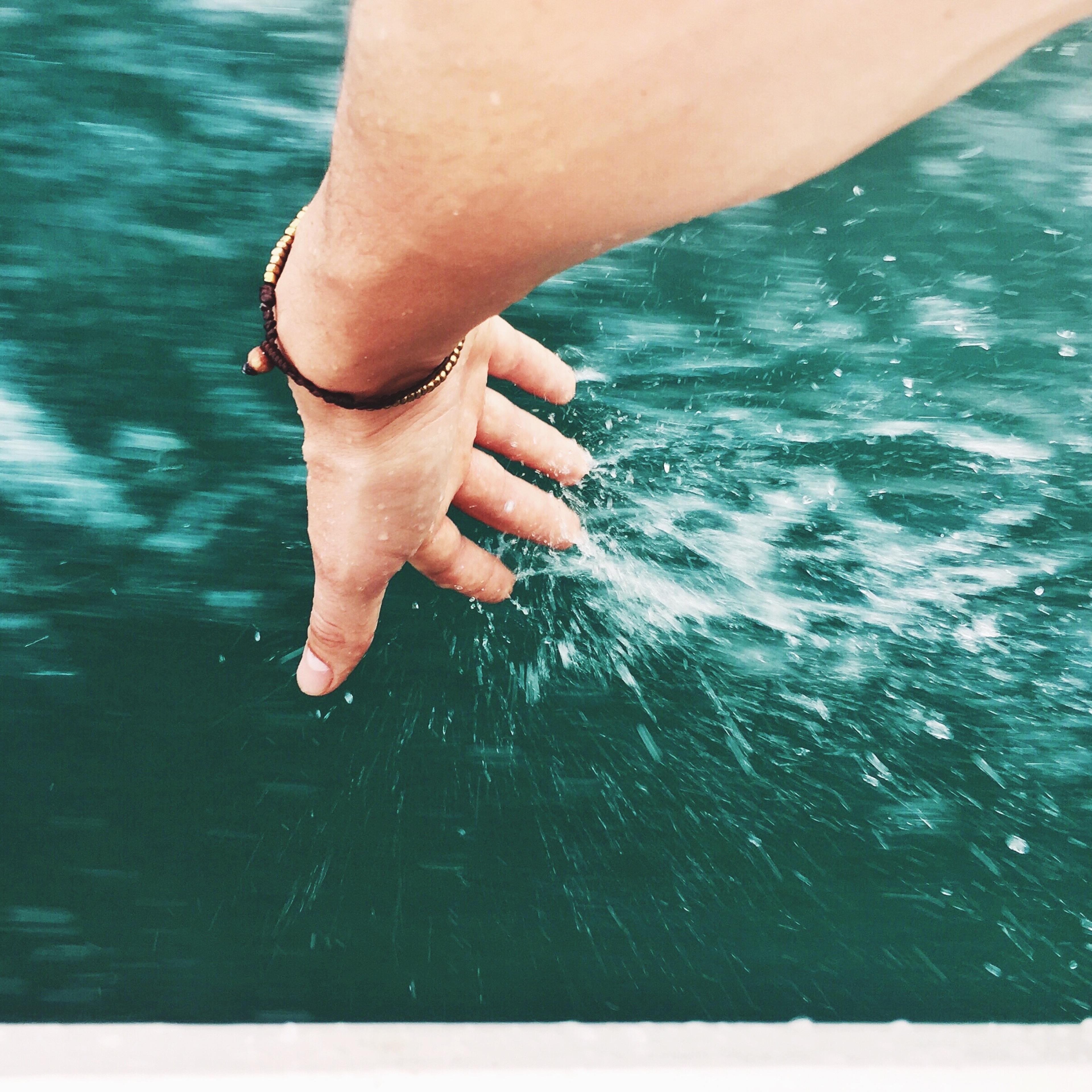 Woman Touching Water While Sitting In Boat