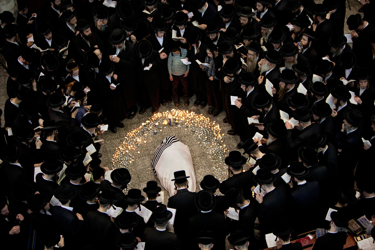 March 14, 2012. Ultra-Orthodox Jews gather around the body of Rabbi Moshe Yehoshua Hager, leader of the~Hassidic sect Vizhnitz in Israel, at the Vizhnitz Synagogue during his funeral procession in Bnei Brak, Israel.