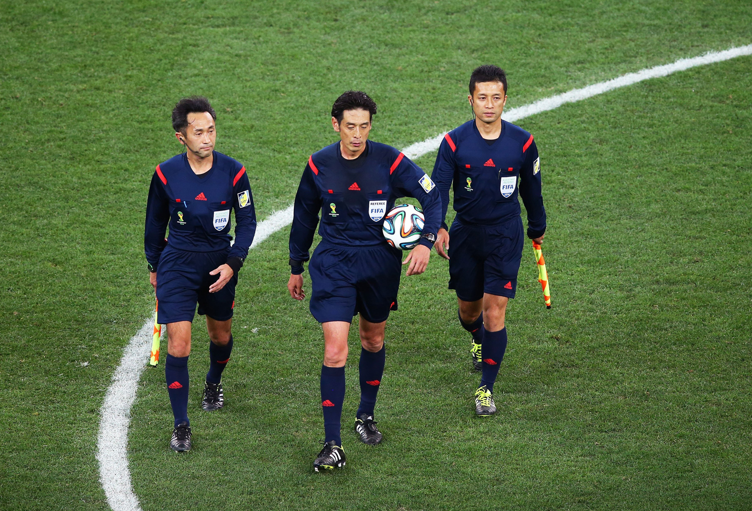 Assistant referee Toshiyuki Nagi, referee Yuichi Nishimura and assistant referee Toru Sagara of Japan walk on the field at the end of the match during the 2014 FIFA World Cup Brazil Group A match between Brazil and Croatia at Arena de Sao Paulo on June 1