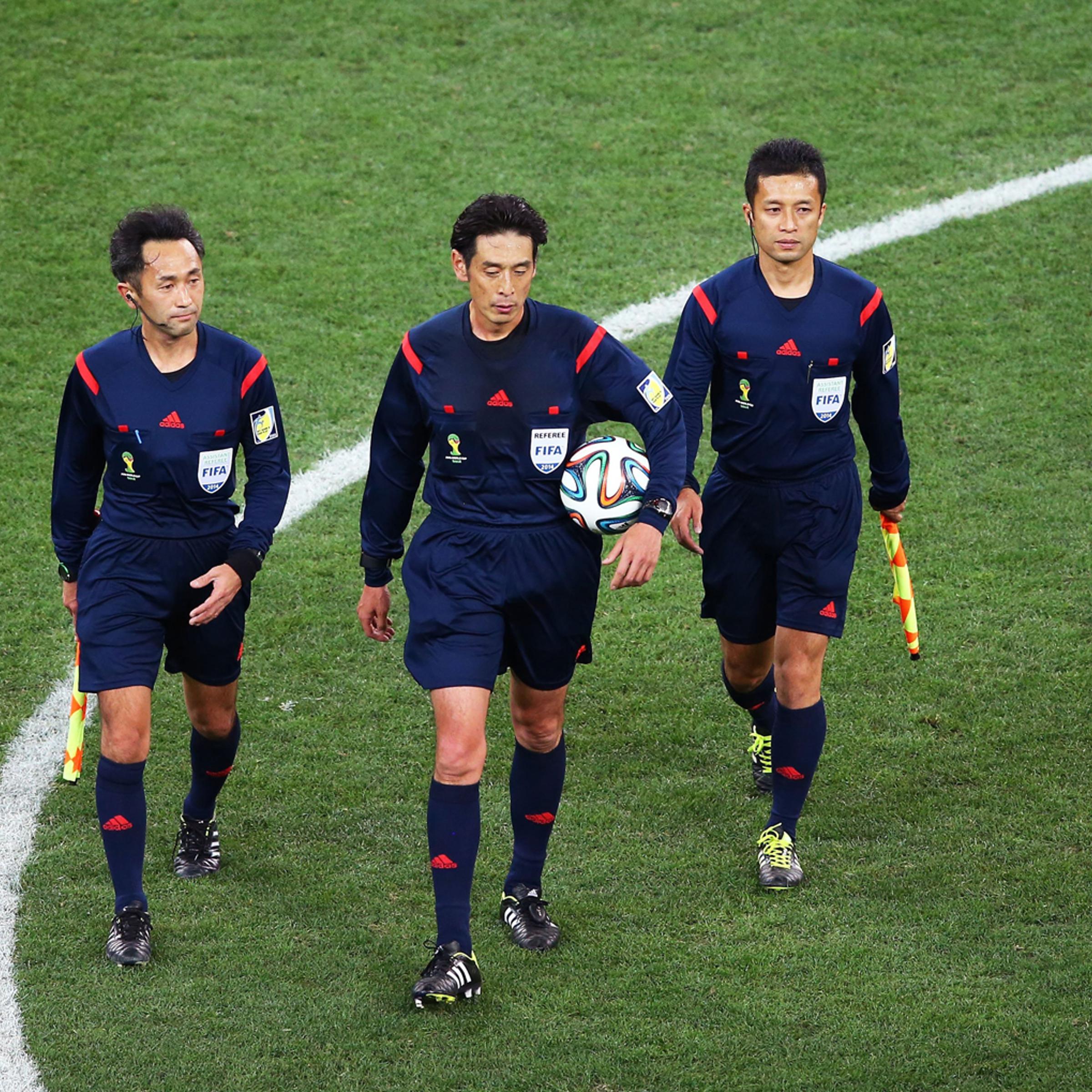 Assistant referee Toshiyuki Nagi, referee Yuichi Nishimura and assistant referee Toru Sagara of Japan walk on the field at the end of the match during the 2014 FIFA World Cup Brazil Group A match between Brazil and Croatia at Arena de Sao Paulo on June 1