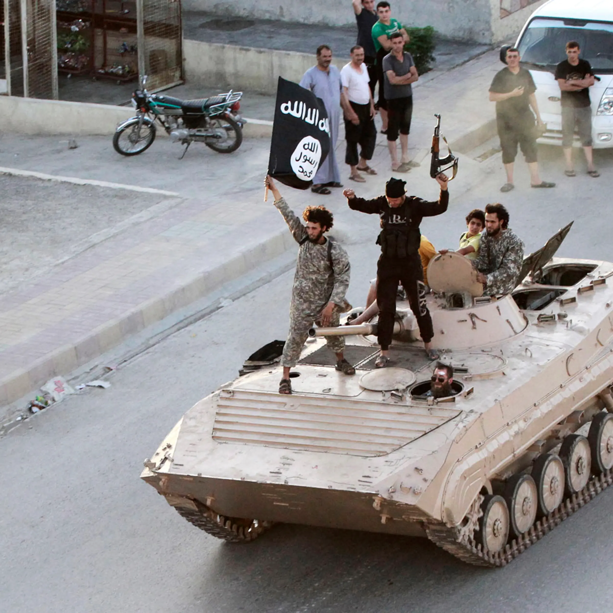 Militant Islamist fighters take part in a military parade along the streets of northern Raqqa province in Syria, June 30, 2014.