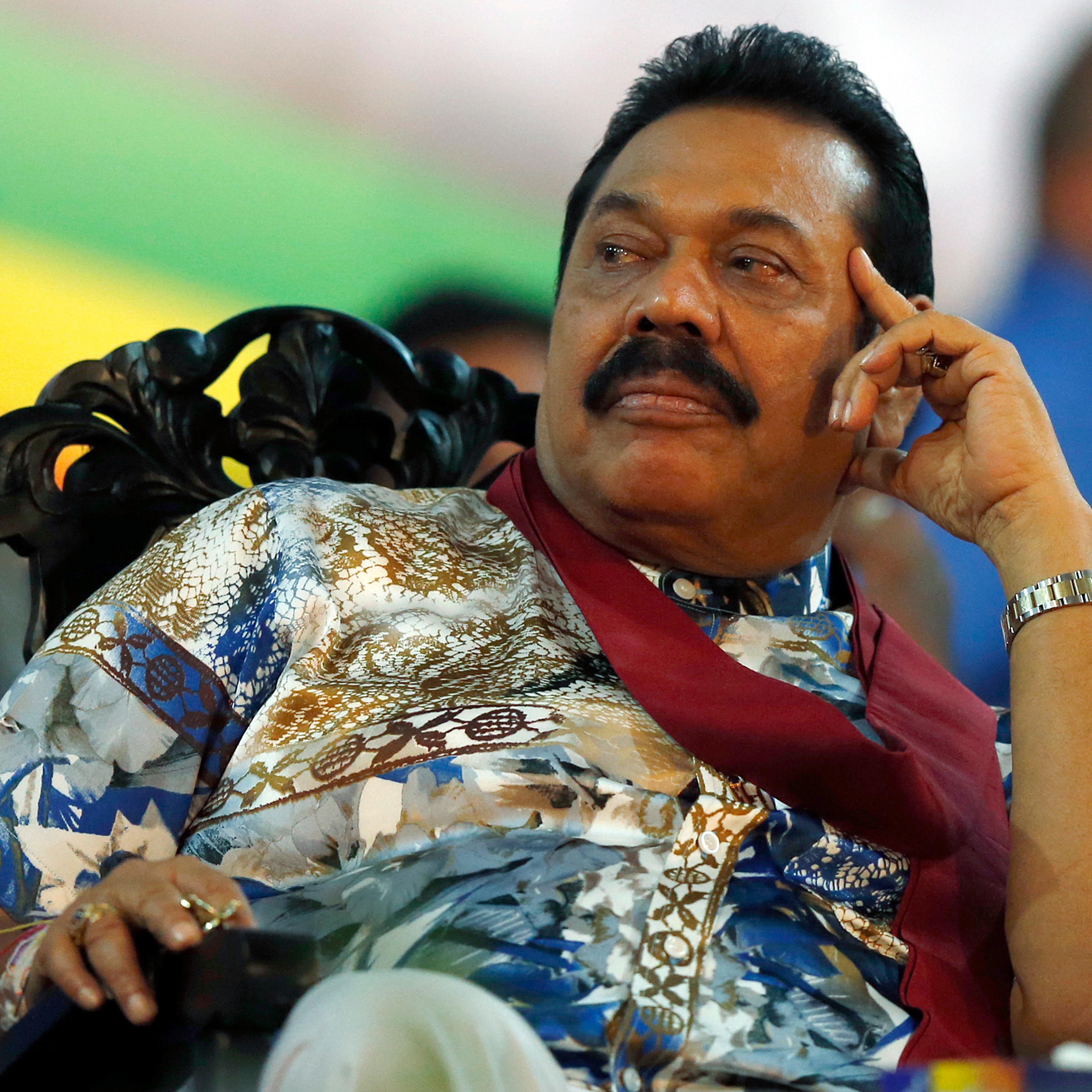 Sri Lankan President Mahinda Rajapaksa listens to a speech during his final rally ahead of presidential election in Piliyandala