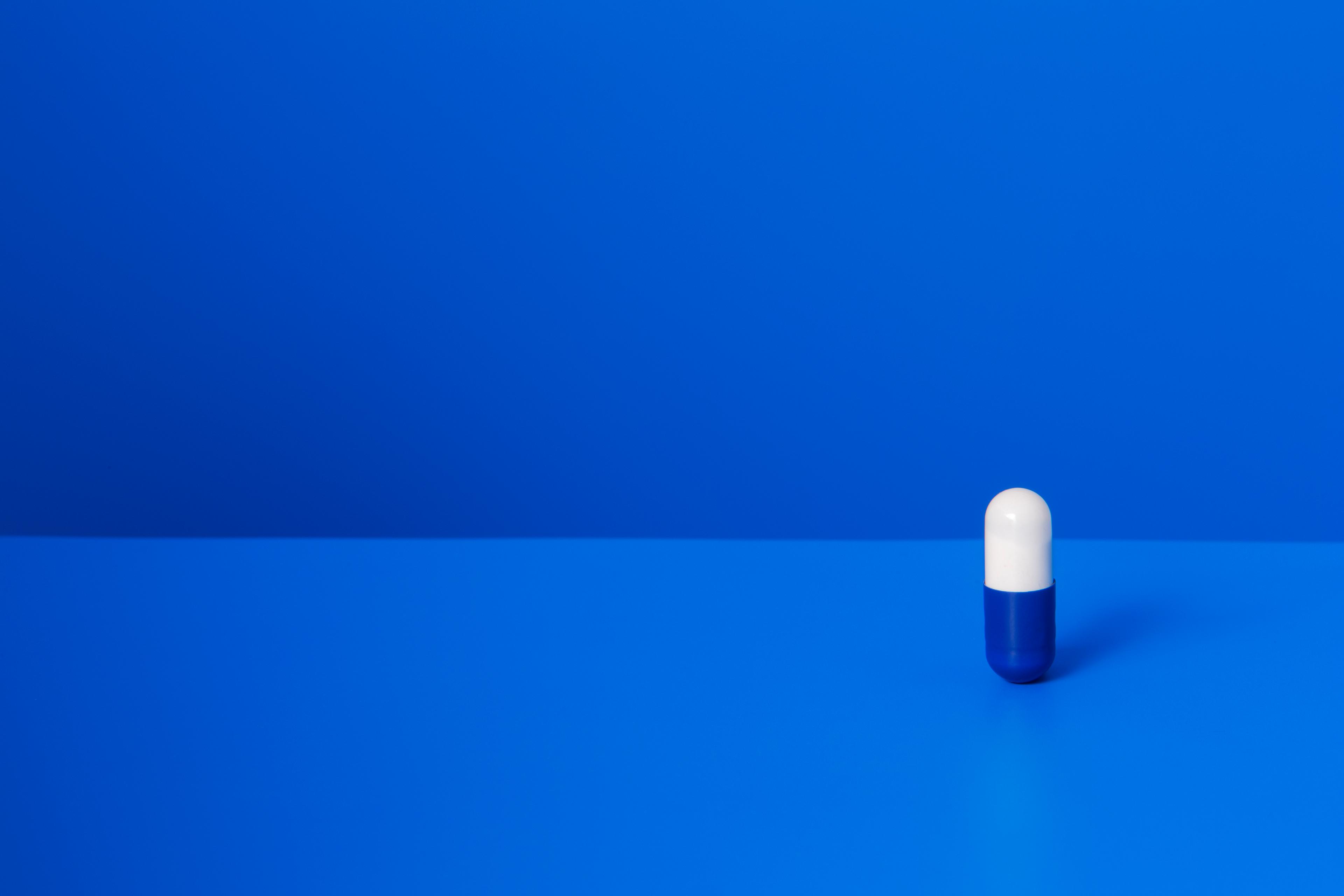 Prescription pill standing upright on blue counter TIME health