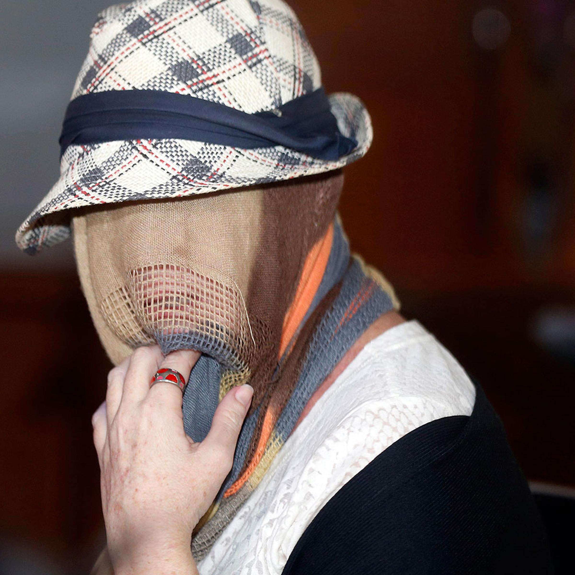 Convicted Australian drug trafficker Schapelle Corby. with her head covered, sits in the Denpasar Parole Board Office following her release from Kerobokan Prison in Bali on Feb. 10, 2014