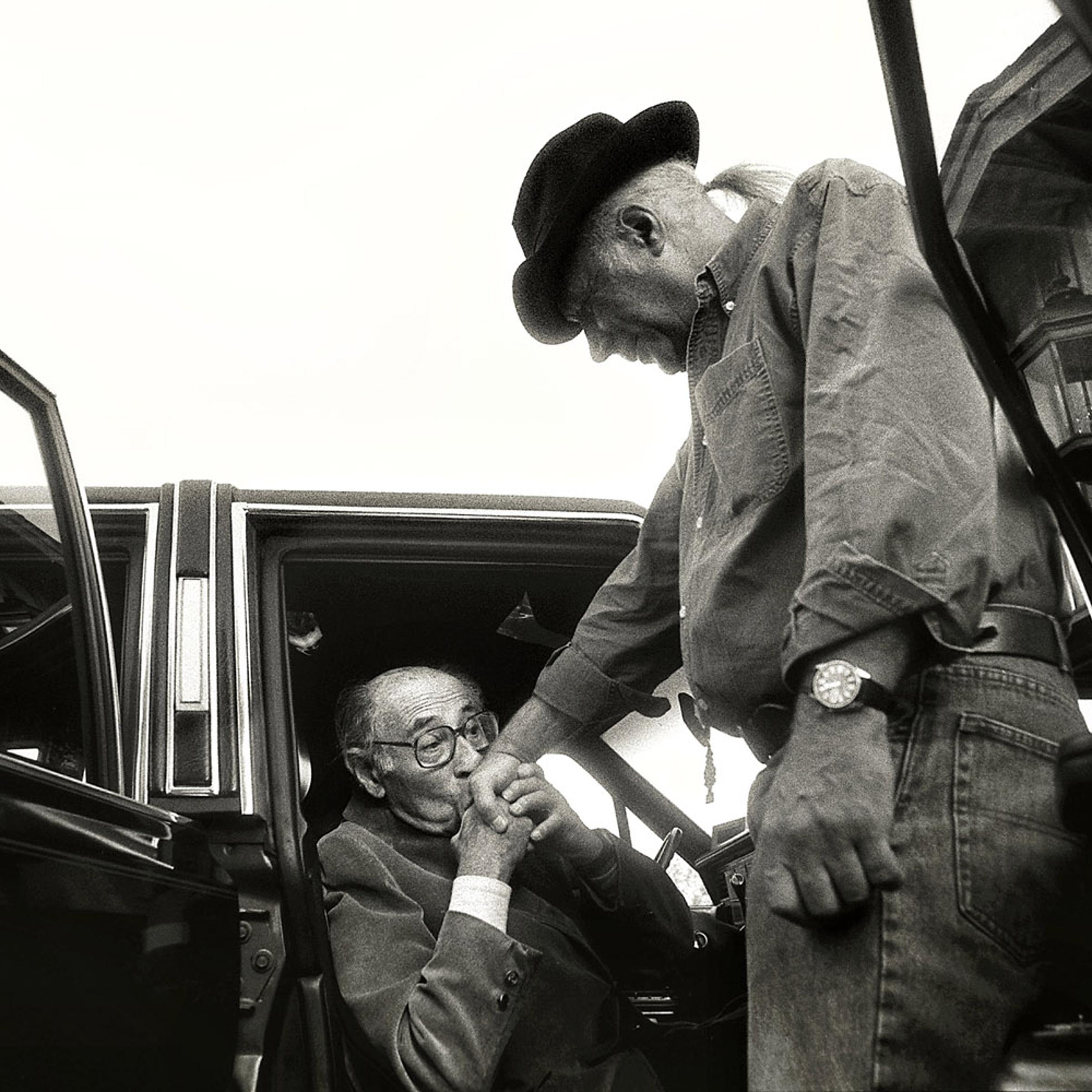 <b>1992: Rick Loomis</b>
<br /><br />
Alfred Eisenstaedt kisses the hand of Eddie Adams after speaking at the workshop in 1992.
<br /><br />
<i>"The third time was a charm when I applied to the Eddie Adams
Workshop as a student from Western Kentucky University. My first two applications were met with rejection but the experience proved worth the wait. The workshop was intense with a roster full of industry heavies that I had only ever heard about. Speaker after speaker came to the podium sharing their work, their insights, themselves.<br /><br />One of those legends was Alfred Eisenstaedt. When he finished his speech and slowly headed out of the barn, something compelled me to sneak out behind him while everyone else turned their attention to the next speaker. Eddie Adams had also come outside to see him off. Before closing the car door, 'Eisie' kissed Eddie's hand. I was privileged to witness these two giants in the world of photography pay homage to one another.<br /><br />In that m