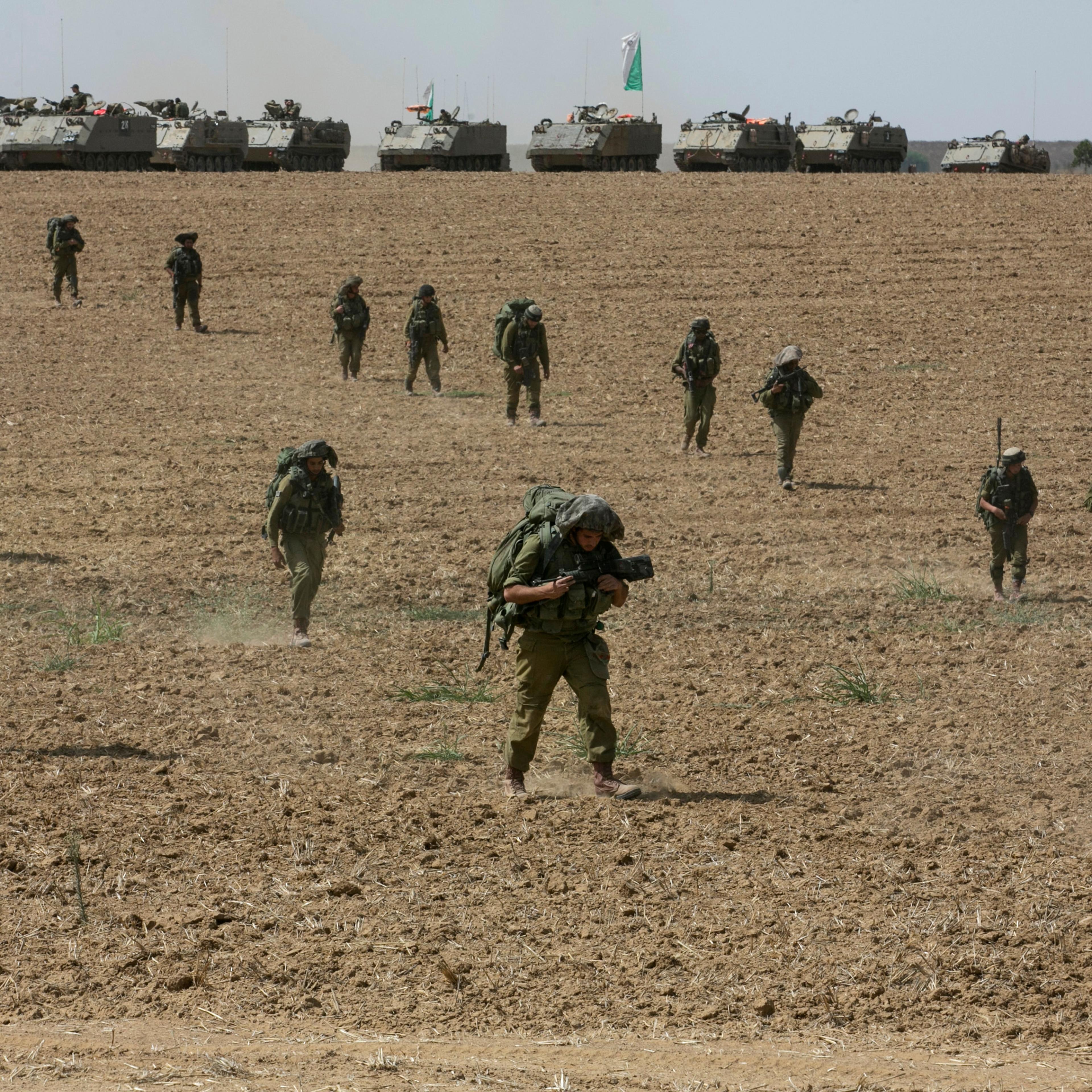 Israeli soldiers from the Nahal Infantry Brigade walk across a field near central Gaza Strip