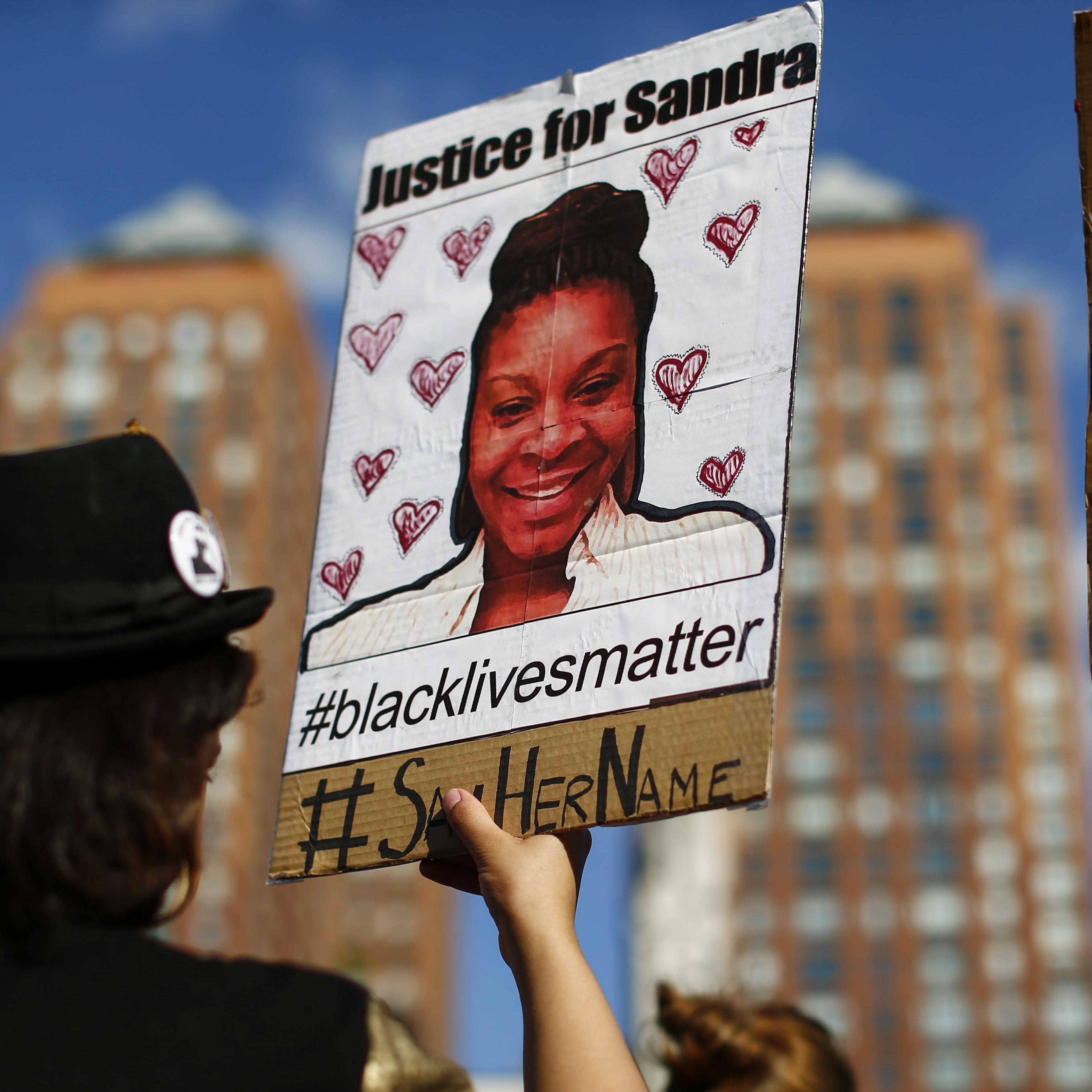 A woman holds a poster bearing the portrait of Sandra Bland, a 28-year-old black woman who killed herself in a Texas jail cell on July 13th, during a Michael Brown memorial rally in Union Square in New York on Aug. 9, 2015.