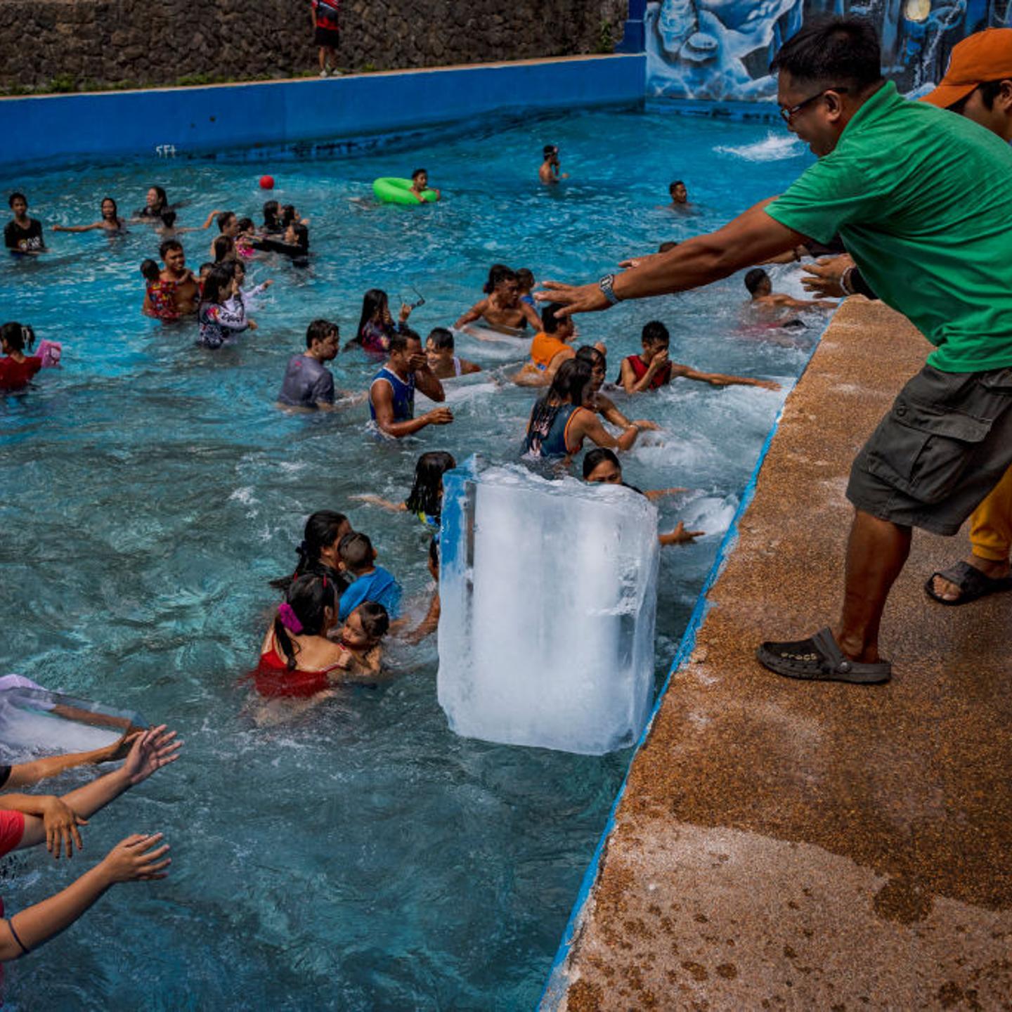 Workers dump blocks of ice at a pool amid extreme heat at the Hidden Sanctuary Resort on May 4, 2024 in Marilao, Bulacan province, Philippines.