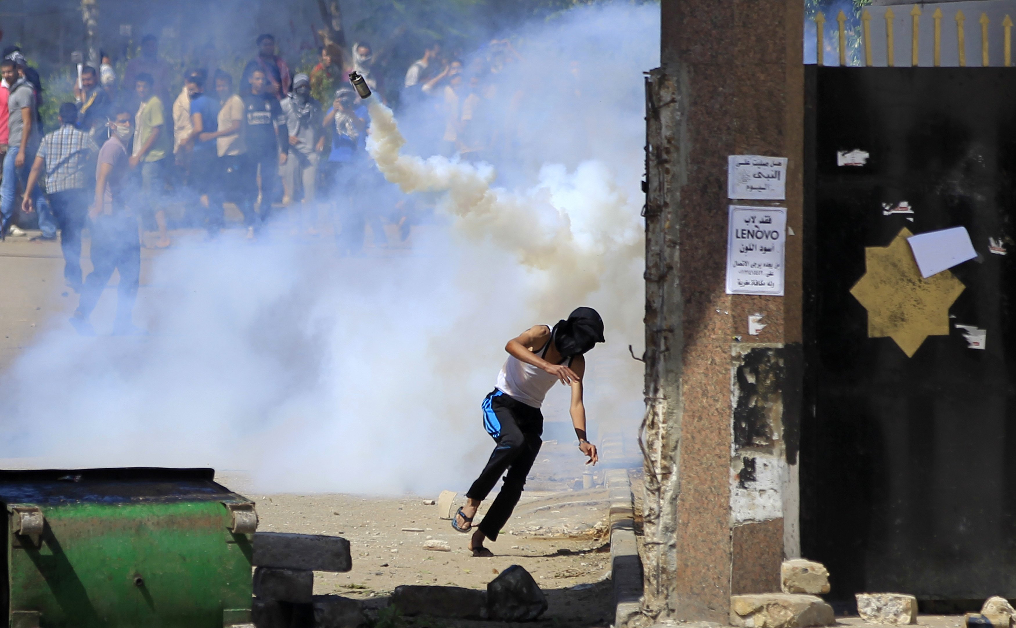 Student supporters of the Muslim Brotherhood and ousted President Mohamed Mursi flee from tear gas and rubber bullets fired by riot police during clashes at Al-Azhar University's campus, in Cairo's Nasr City district, May 9, 2014.