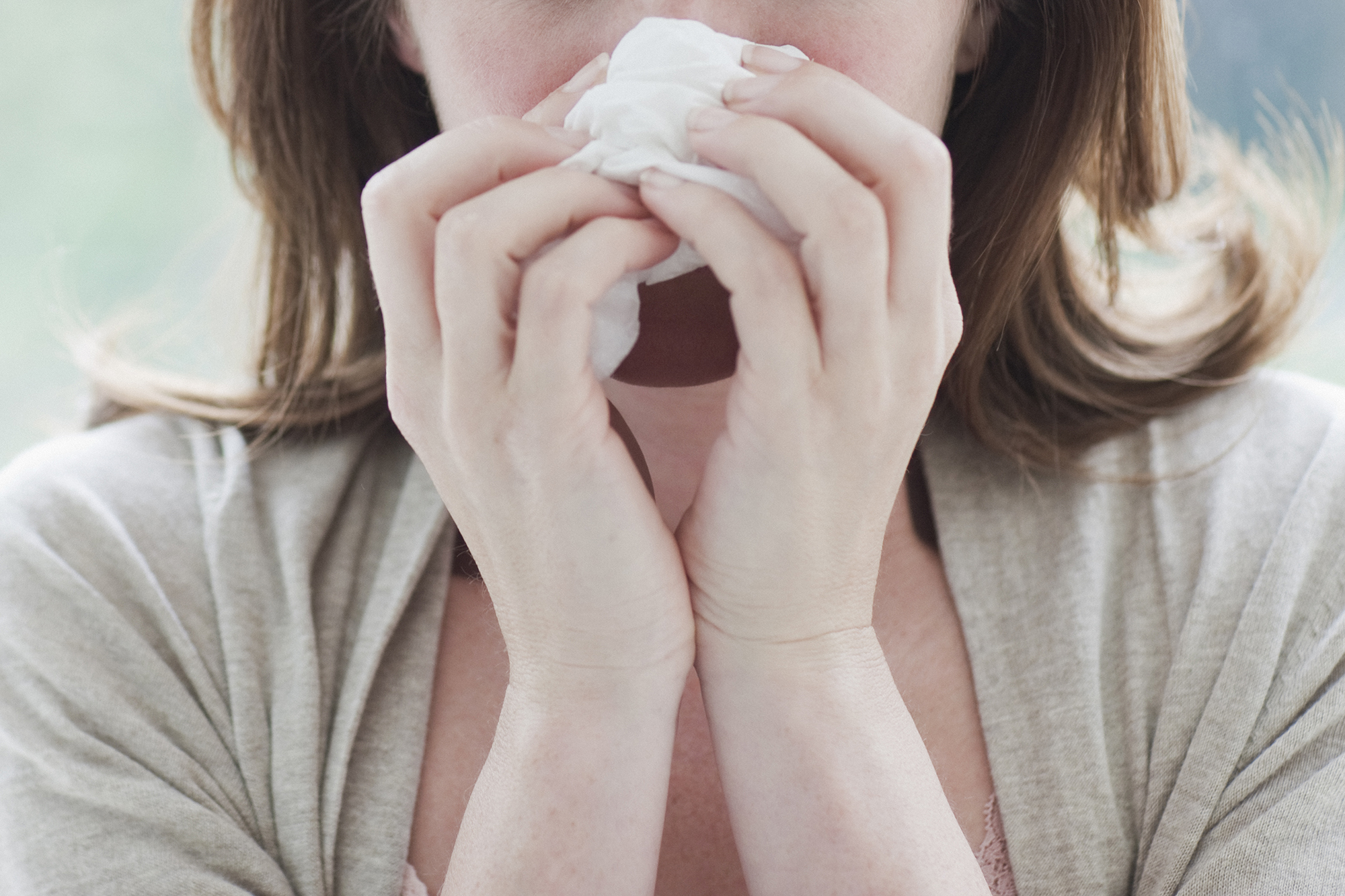 Sick woman wiping her nose