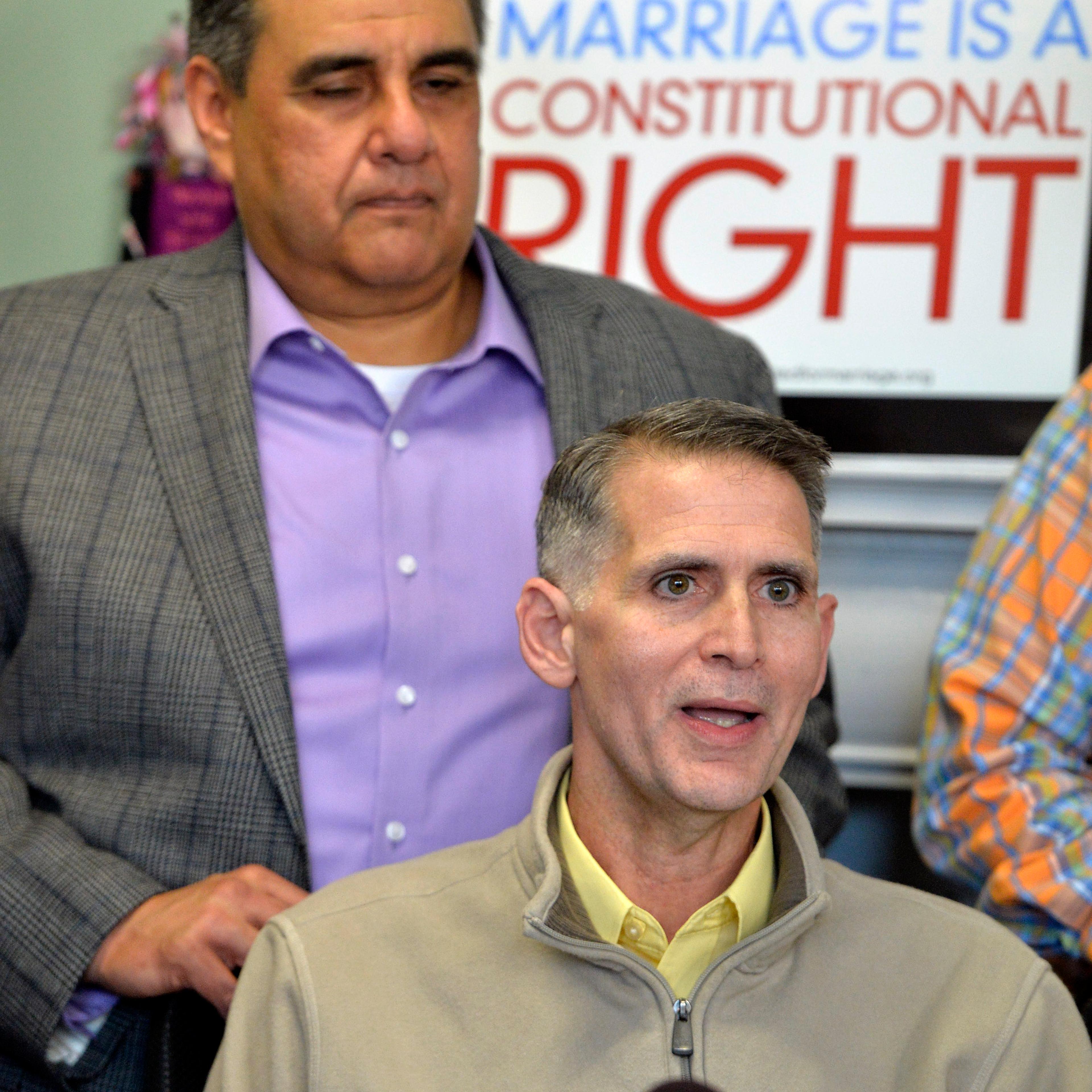 Greg Bourke, front, and his partner Michael Deleon speak to reporters following the announcement from U.S. District Judge John G. Heyburn striking down Kentucky's same-sex marriage ban Wednesday, Feb. 12, 2014, in Louisville, Ky.