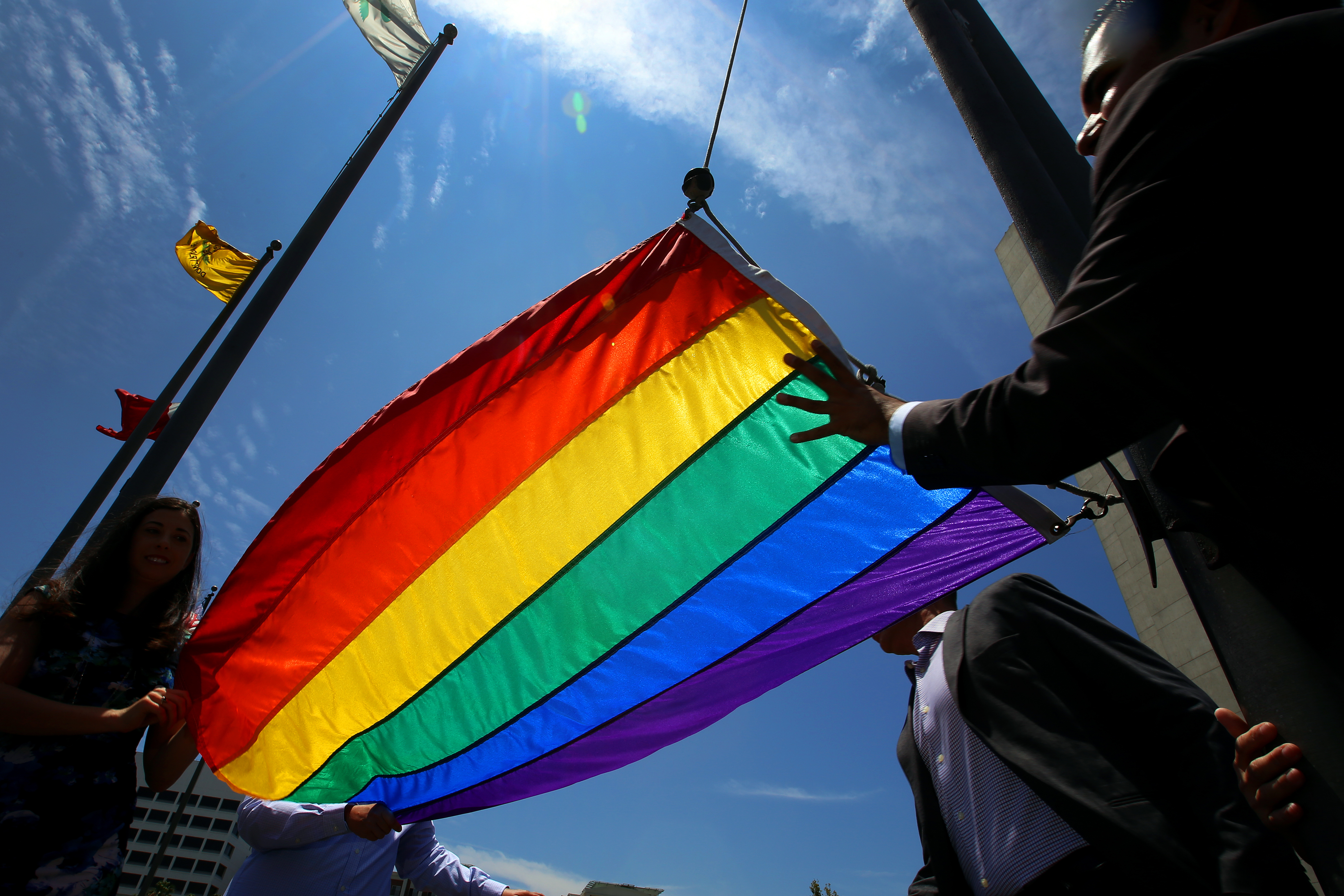 Long Beach Mayor Robert Garcia (R), the city's first openly gay mayor, raises a rainbow Pride Flag over the Civic Plaza on June 26, 2015 in Long Beach, California. The U.S. Supreme Court ruled that same-sex couples have the right marry in all 50 states.