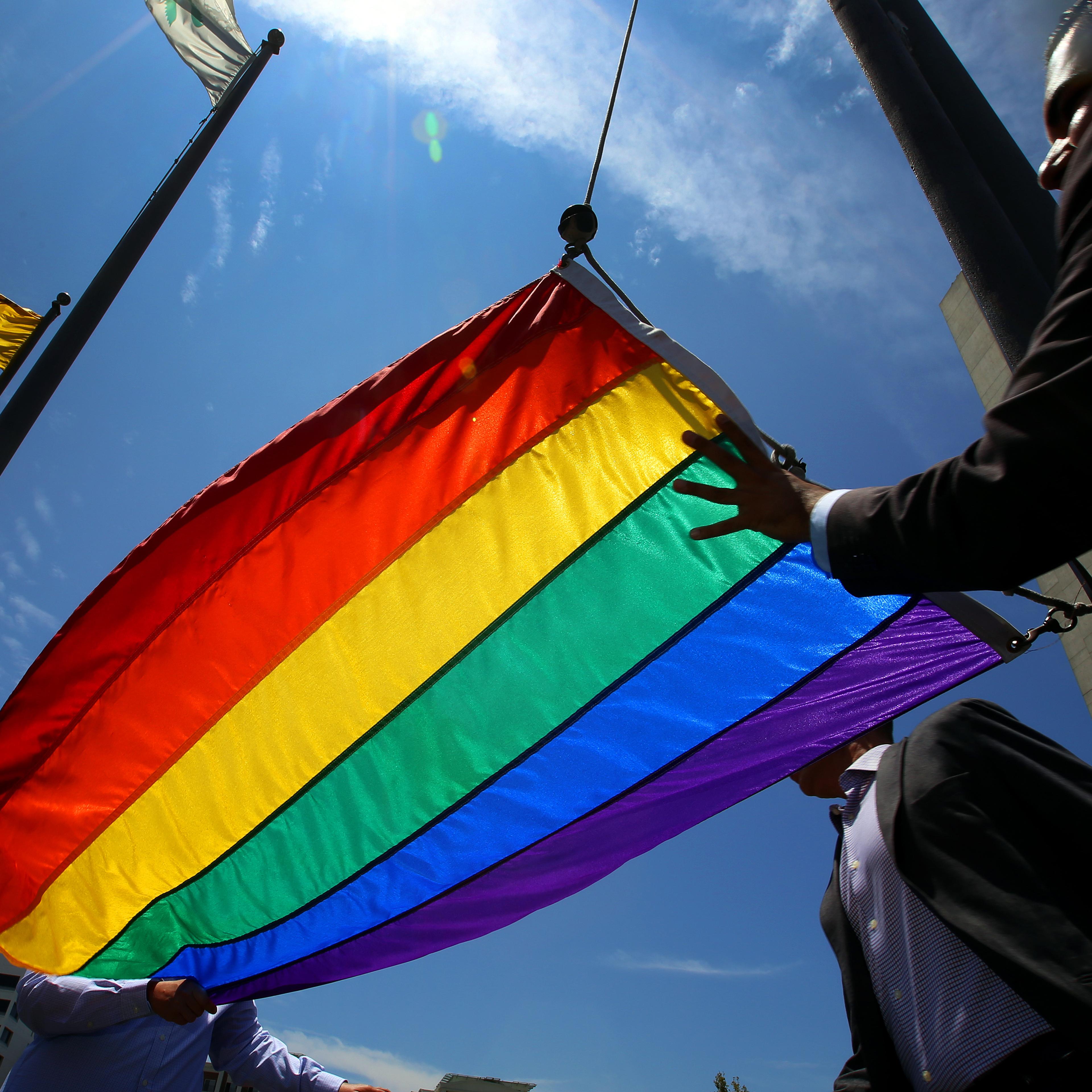 Long Beach Mayor Robert Garcia (R), the city's first openly gay mayor, raises a rainbow Pride Flag over the Civic Plaza on June 26, 2015 in Long Beach, California. The U.S. Supreme Court ruled that same-sex couples have the right marry in all 50 states.