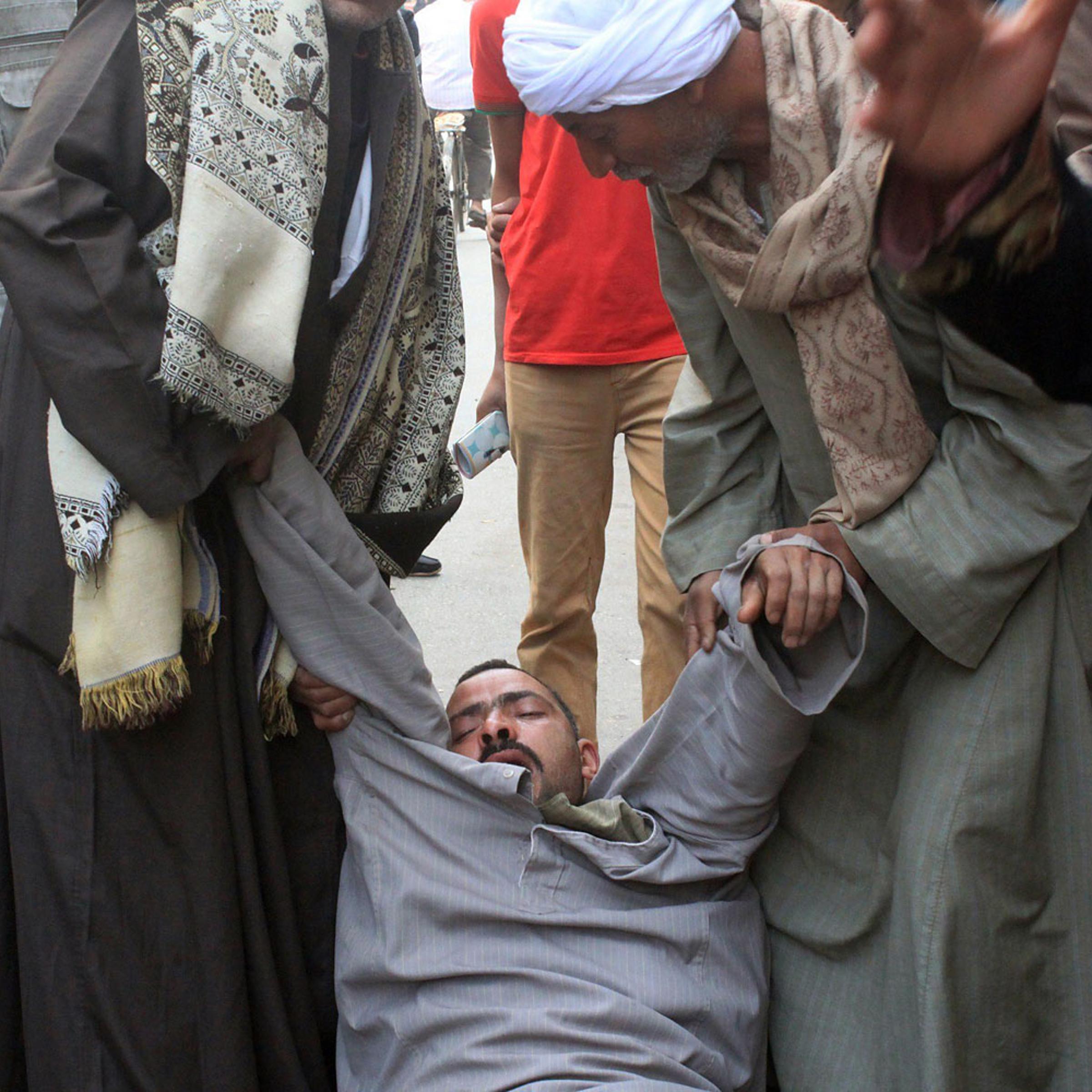 A relative of a supporter of Egyptian ousted Islamist president Mohamed Morsi is supported as he faints outside the courthouse on March 24, 2014 in the central Egyptian city of Minya, after the court ordered the execution of 529 Morsi supporters after on