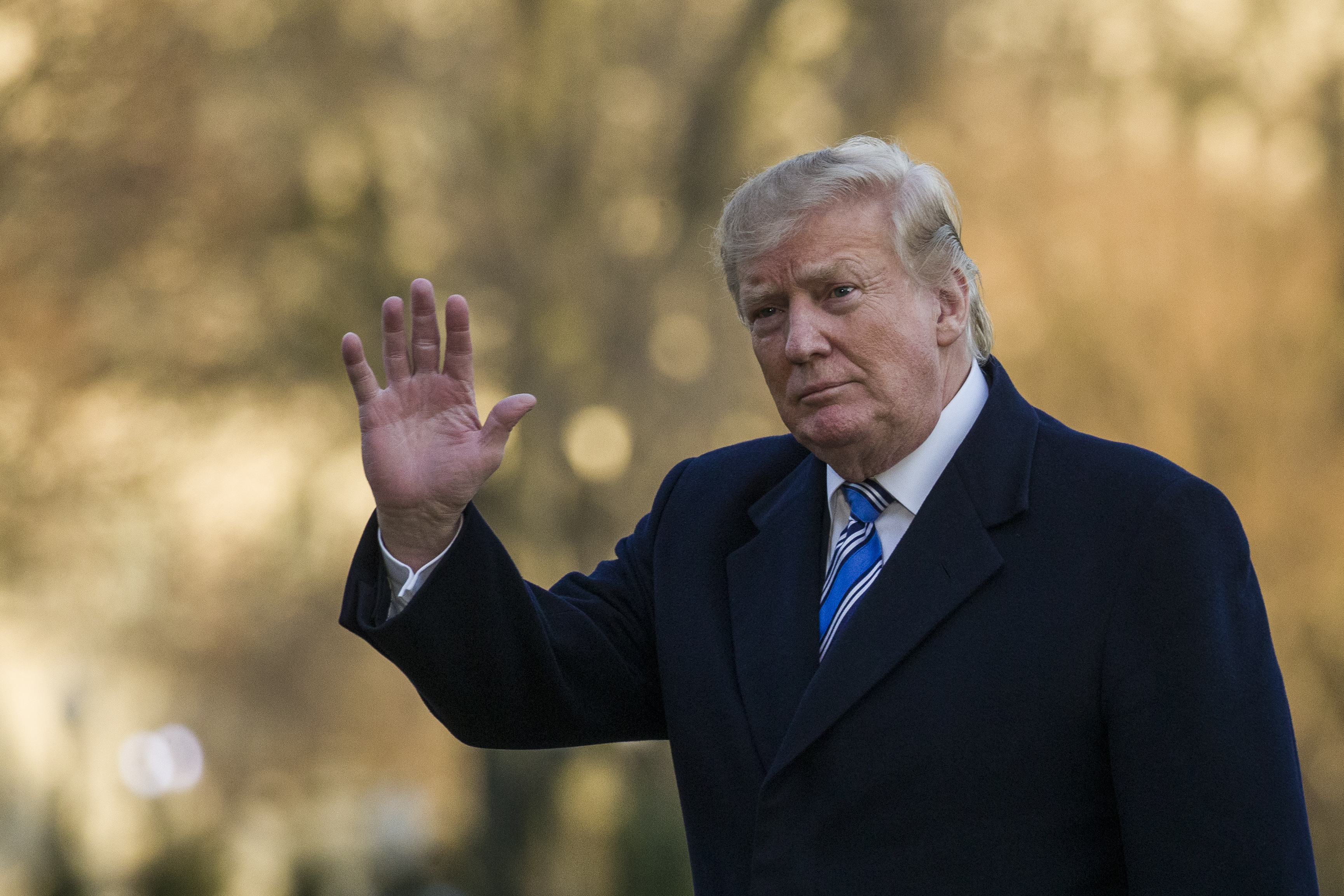 President Donald Trump waves as he walks on the South Lawn